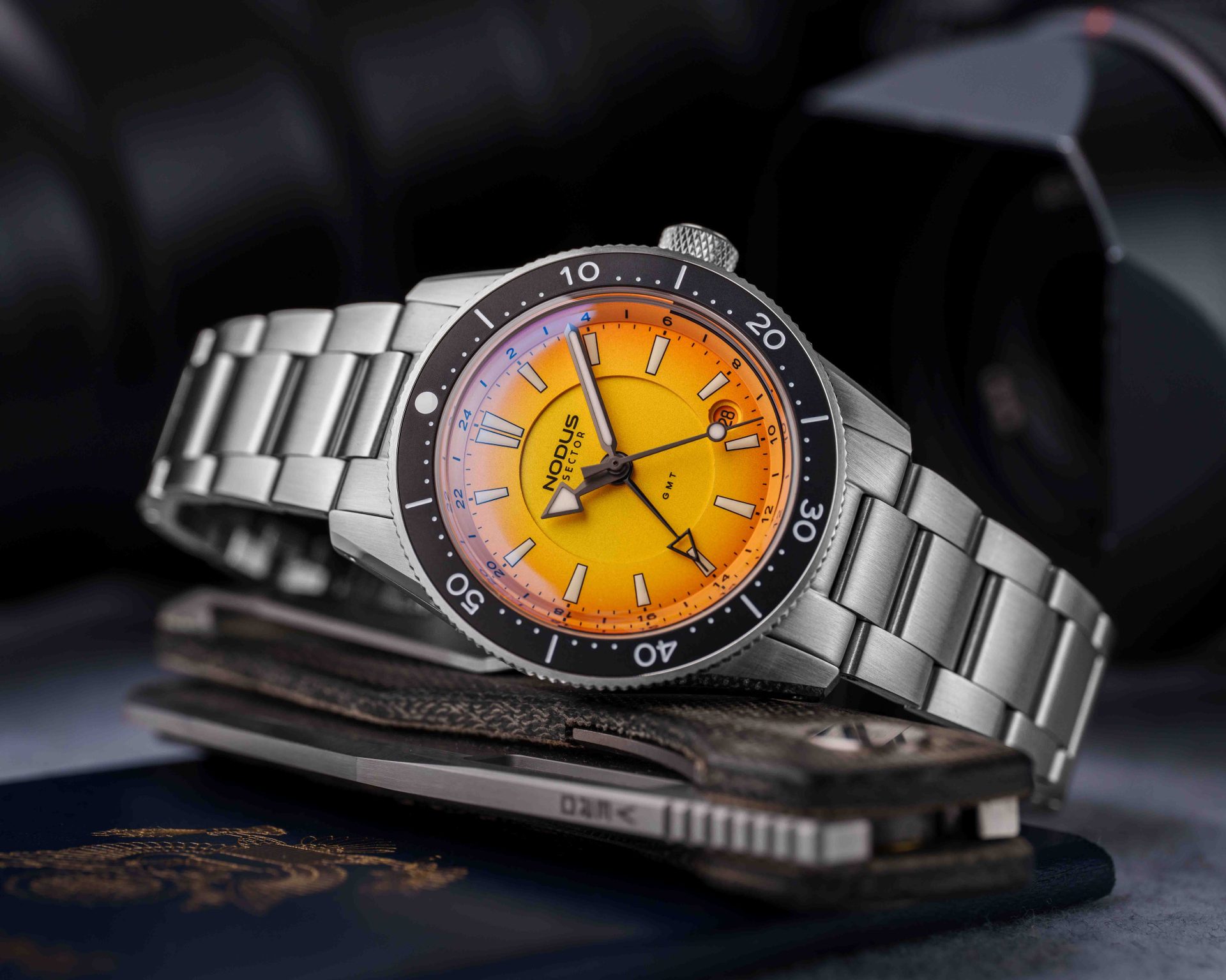 the dial on an orange steel dive watch