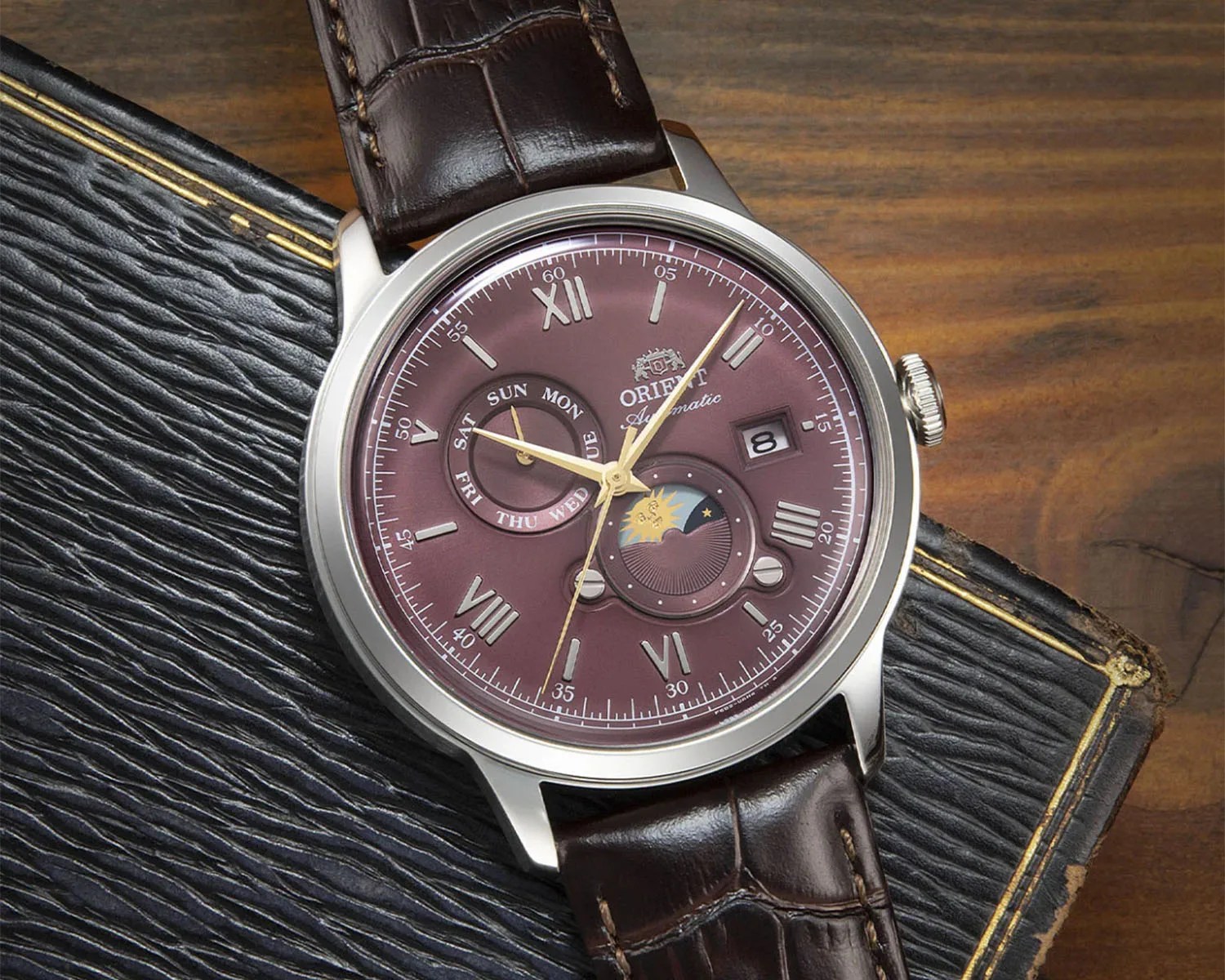 a red dial dress watch with a brown strap
