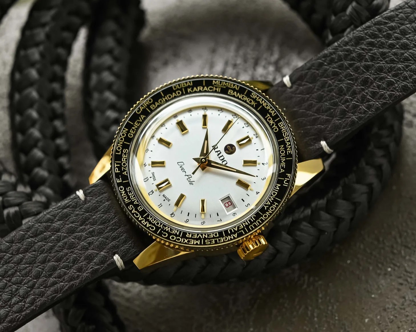 a gold watch with a black leather strap
