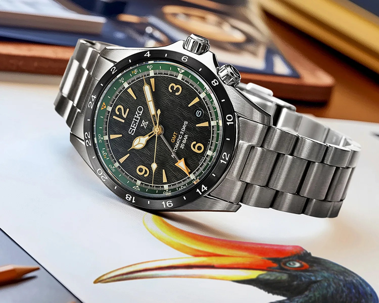 a black gmt watch with a steel bracelet laying sideways on a table