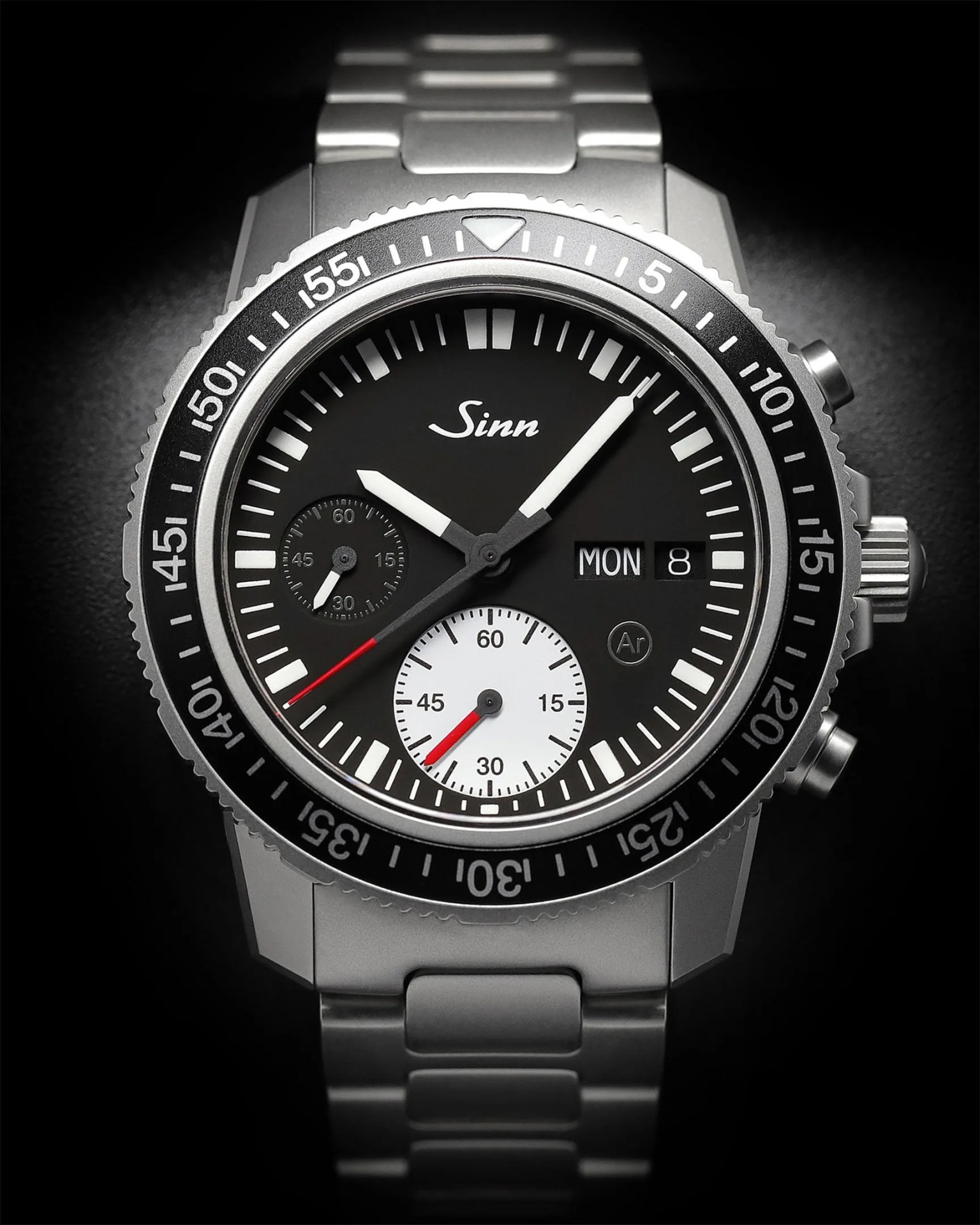 a steel dive watch with a black dial on a black background