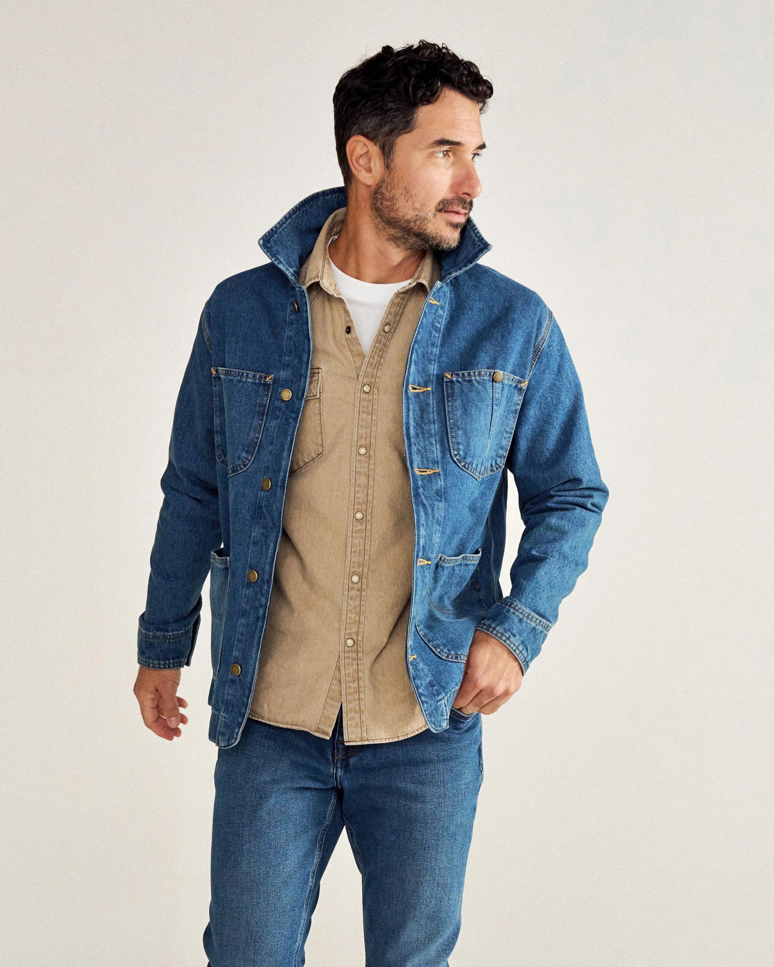 a man in a denim chore coat