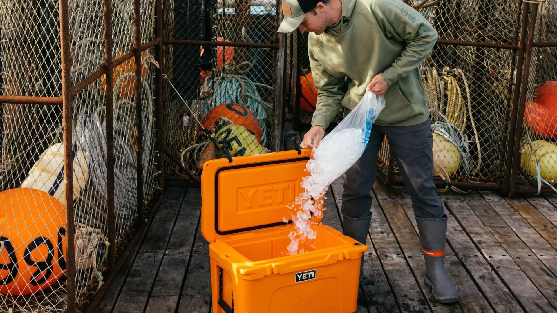 man adding ice to an orange cooler