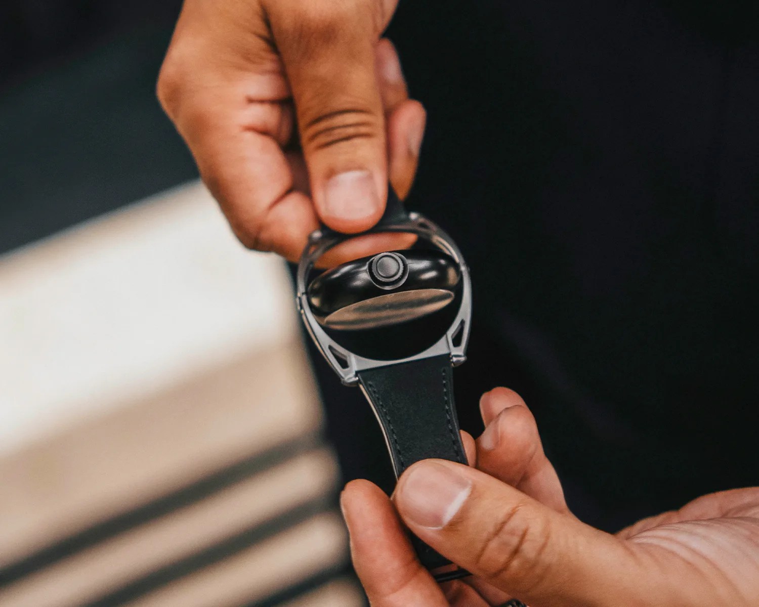 a man holds a de bethune watch with a rotating case