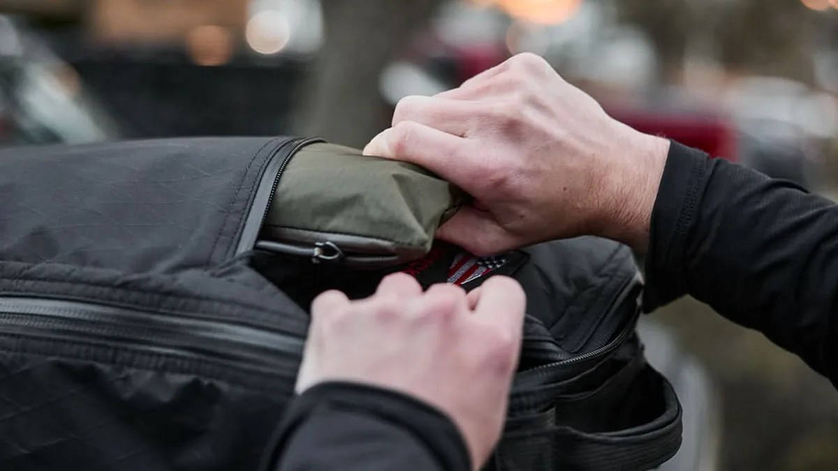 collapsed GoRuck Packable Bullet bag being pulled out of GR1 backpack