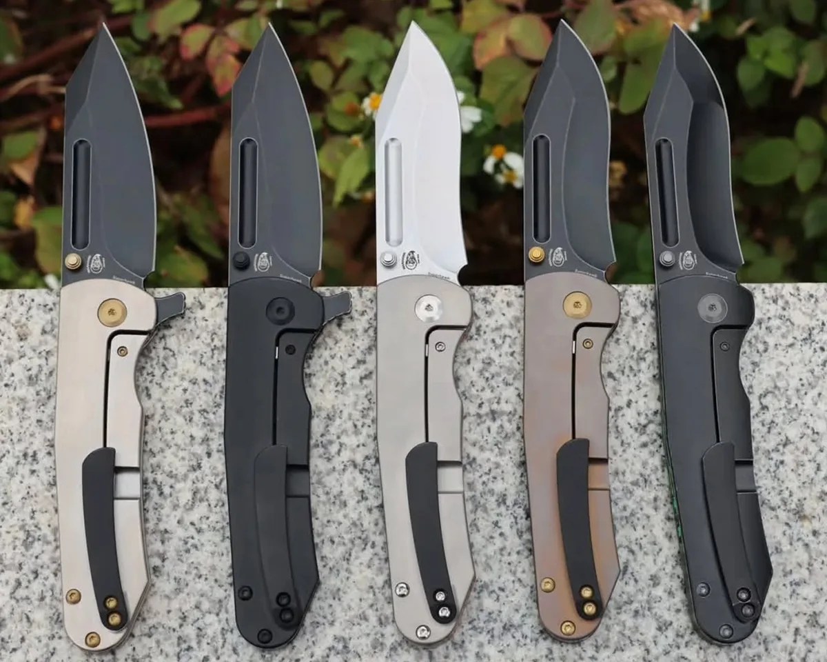 Kansept Superhawk knives on slate in front of flowers
