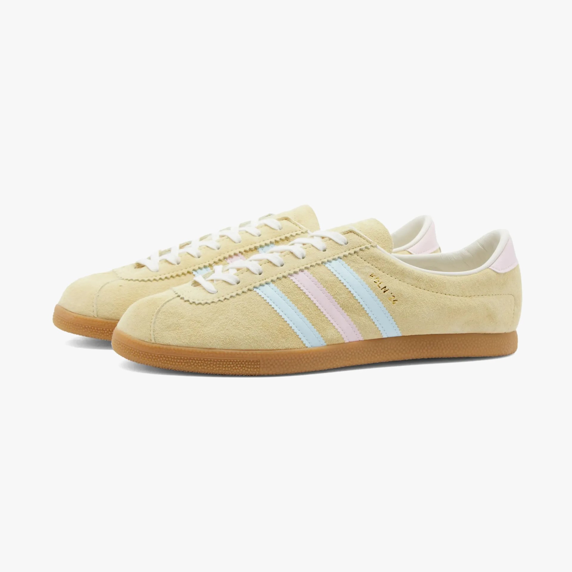 a pair of cream colored adidas sneakers