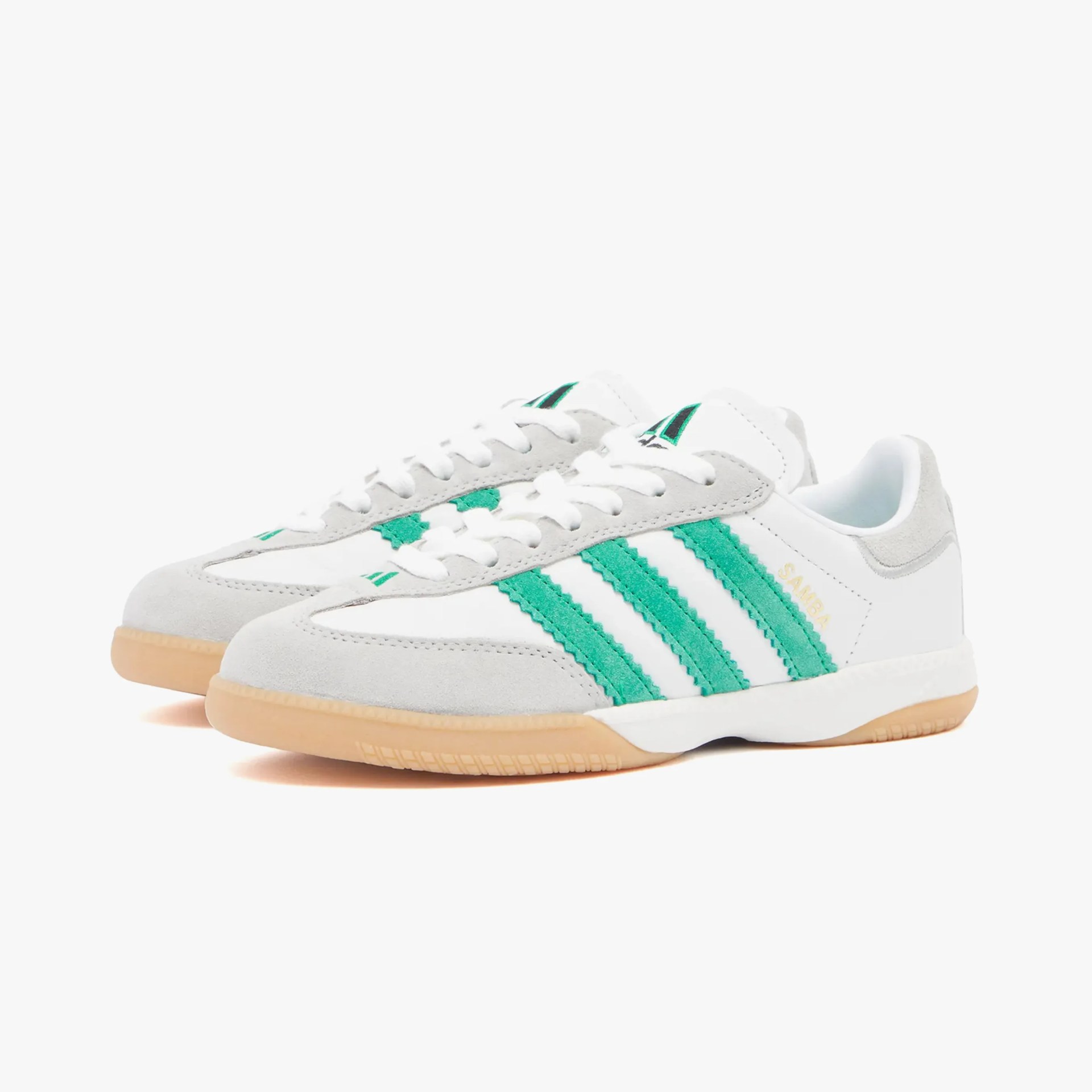 a pair of white and green adidas sneakers