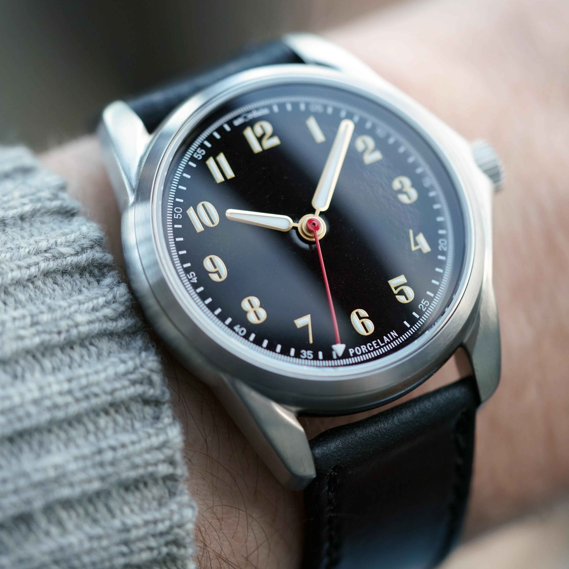 a black dial watch on a black leather stap