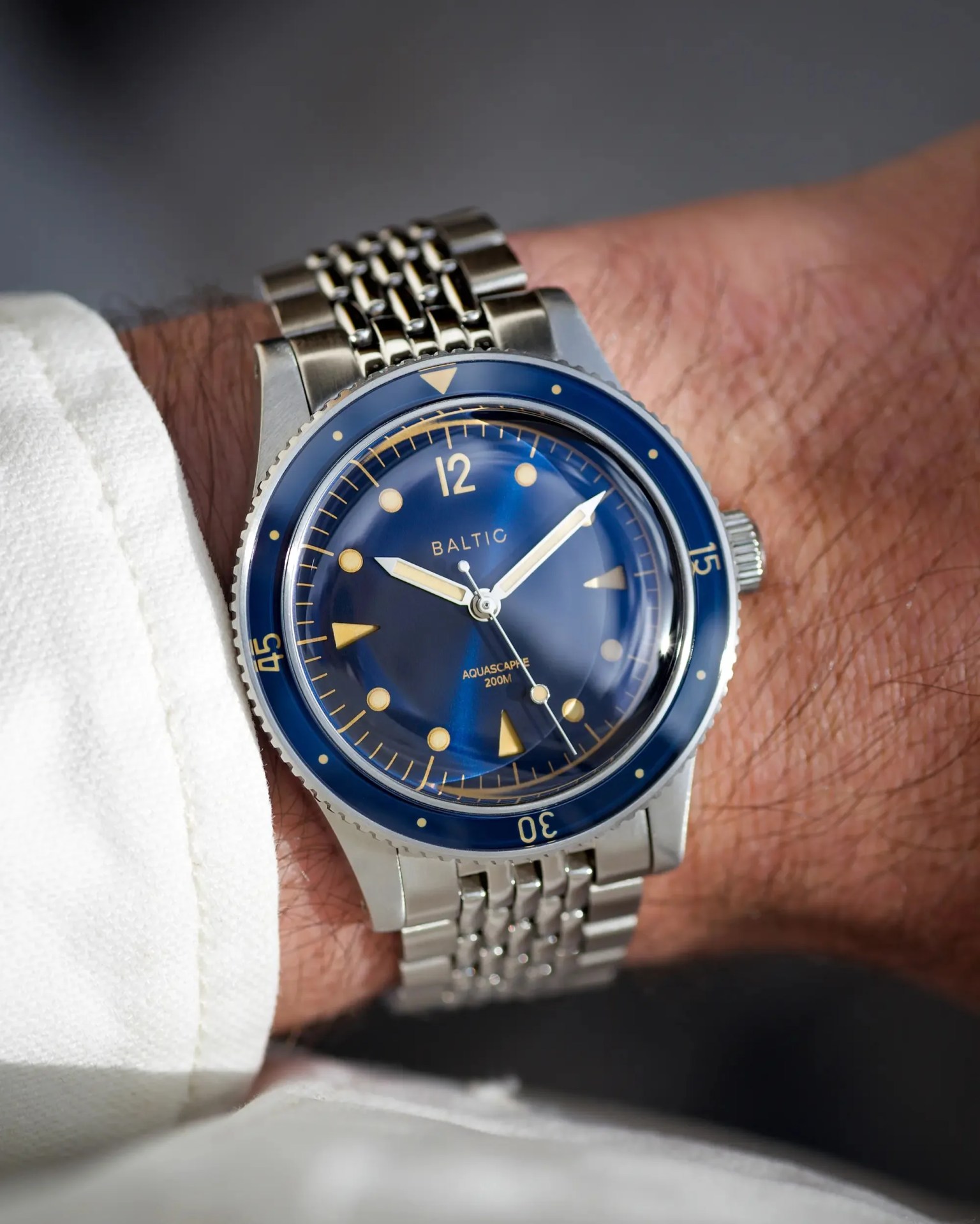 a blue Baltic dive watch on a man's wrist