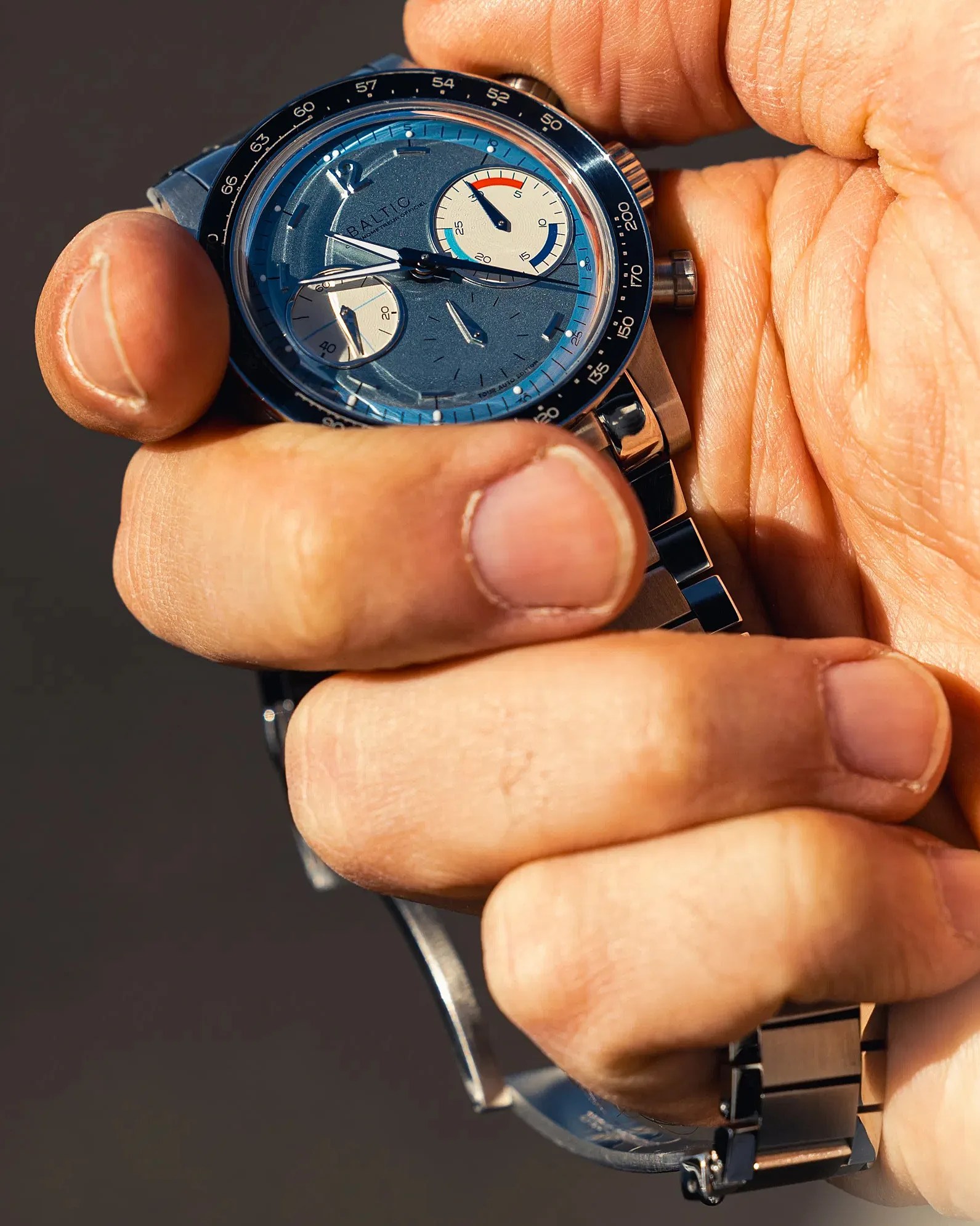 a man holding a Baltic chronograph
