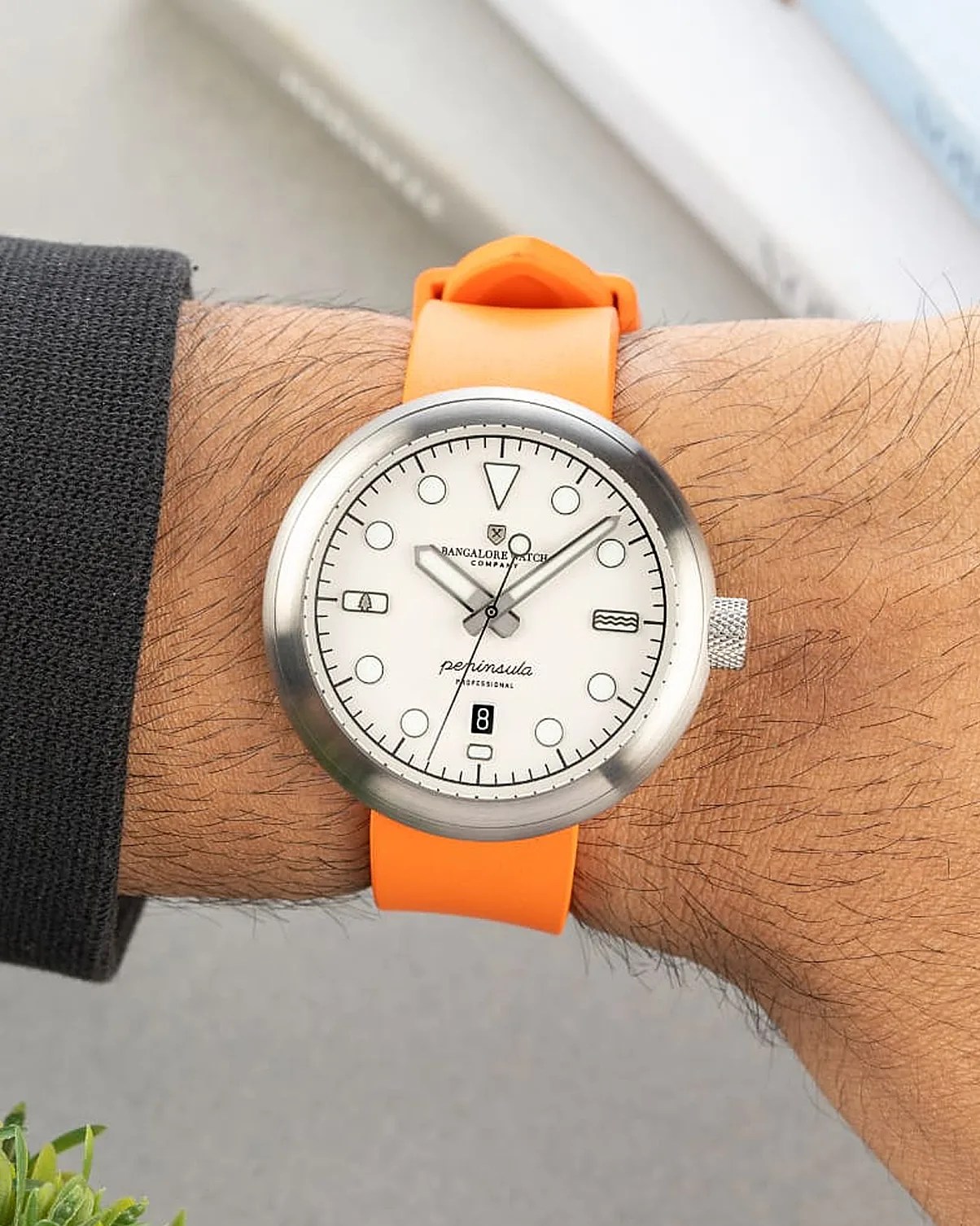 a white field watch on an orange strap