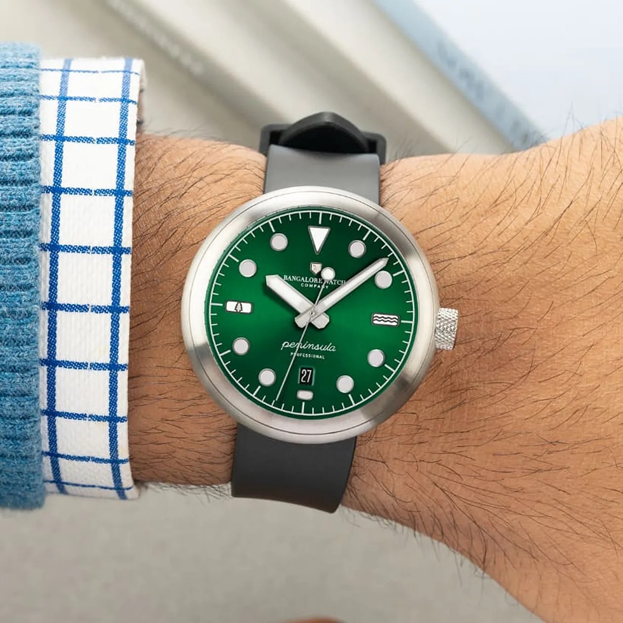 a green field watch on a man's wrist