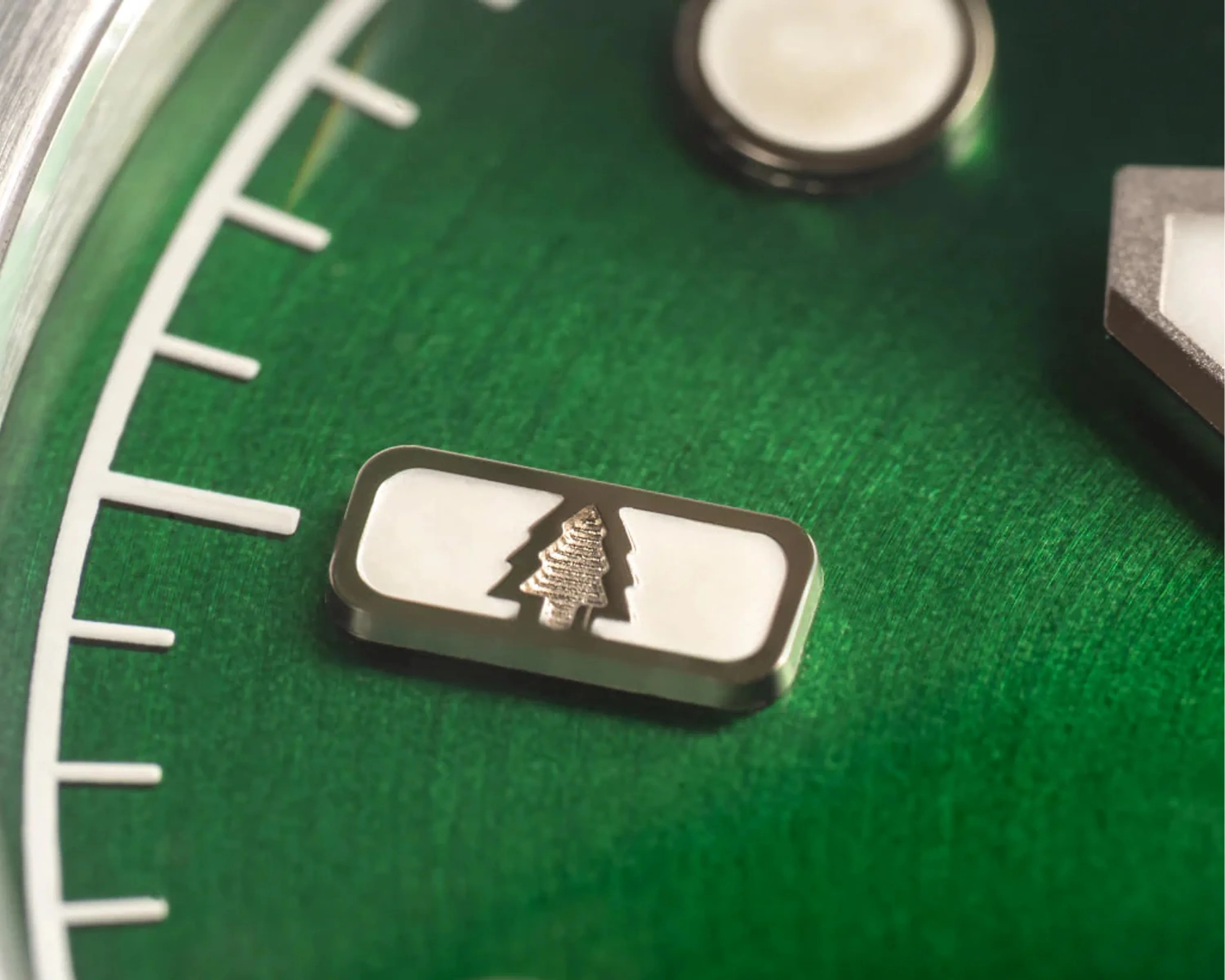 engraved hour marker on the green dial on a field watch
