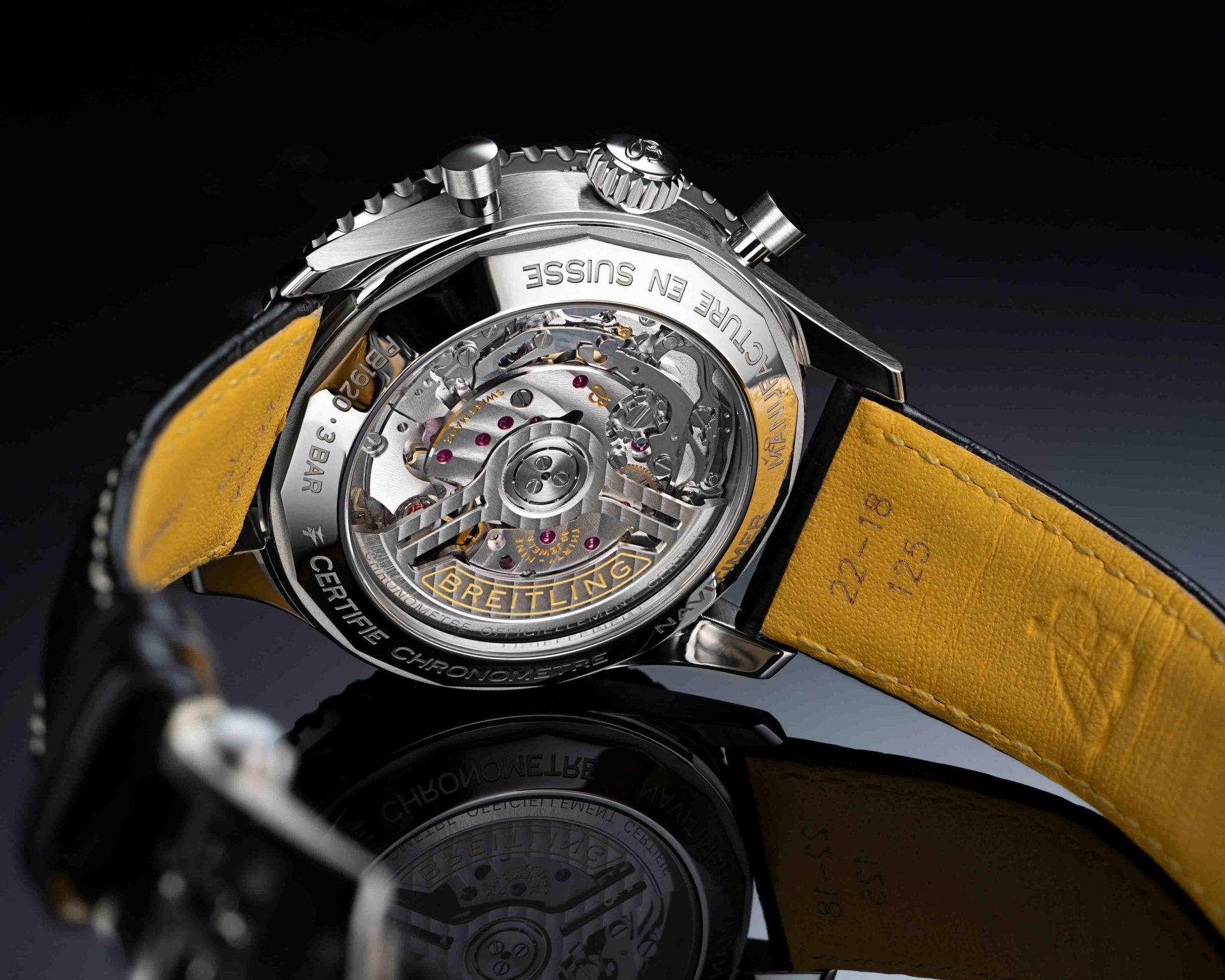 the case back and black leather strap of a Breitling watch
