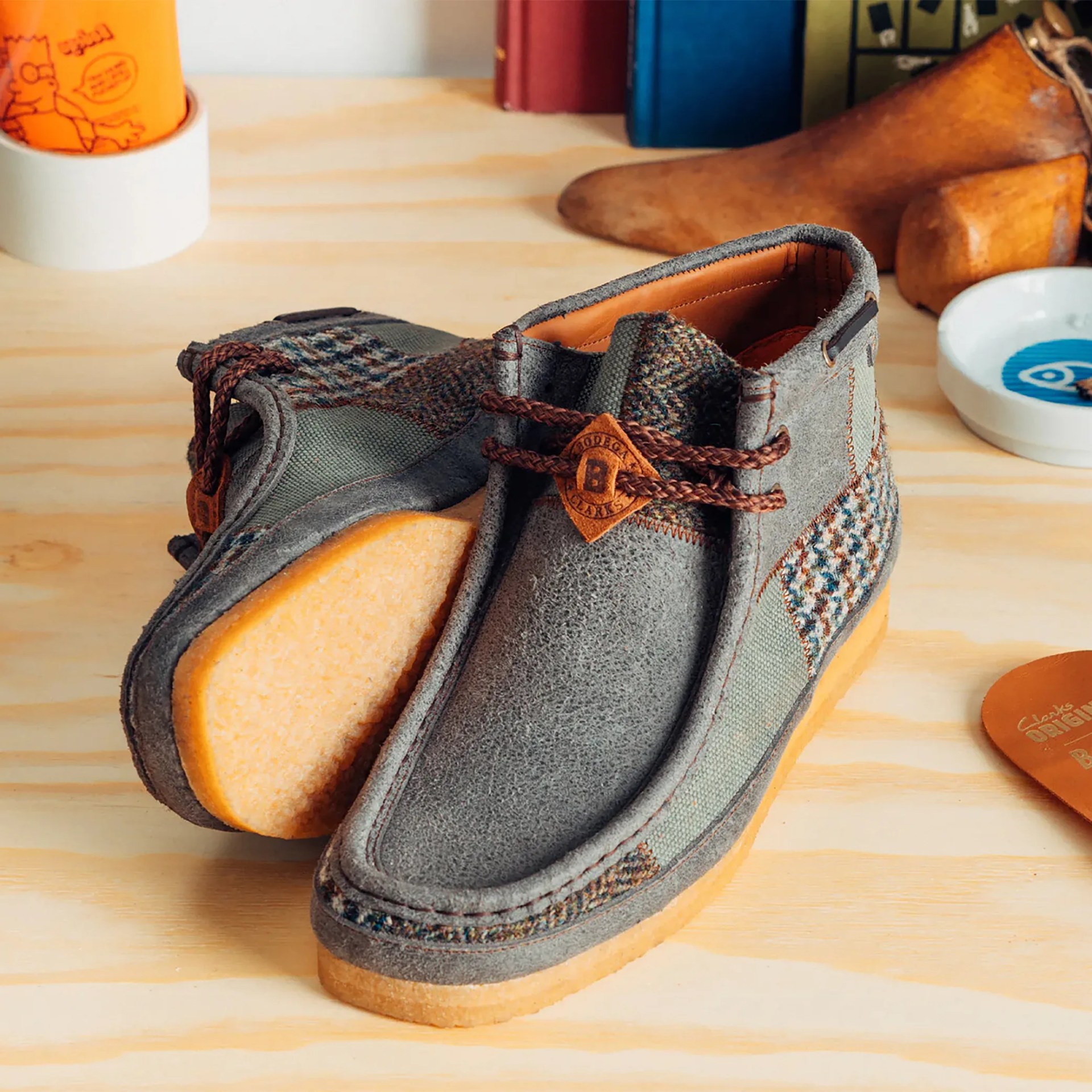 a pair of patchwork clarks wallabee boots sitting on a desk