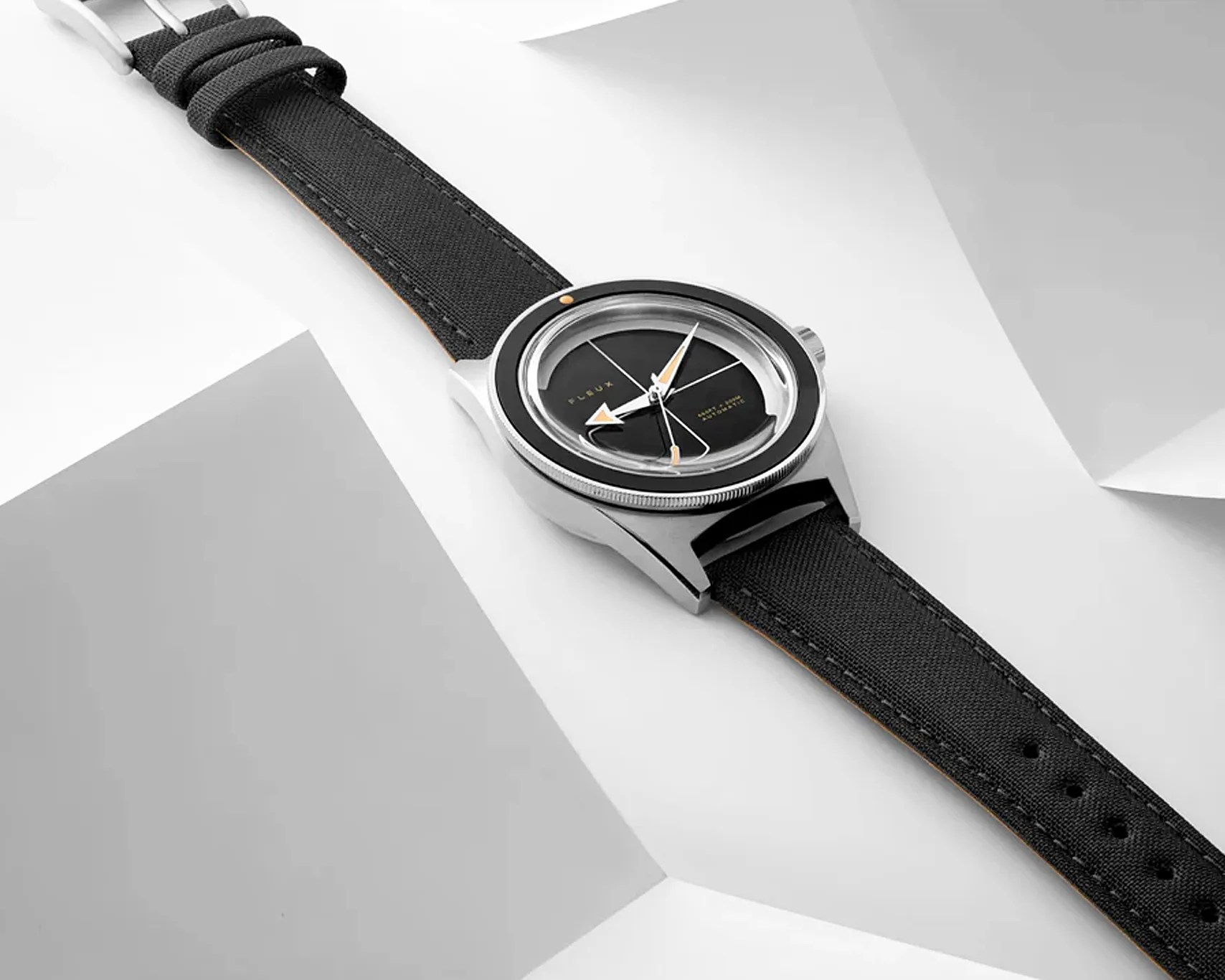 a Fleux black dial watch laying on a table
