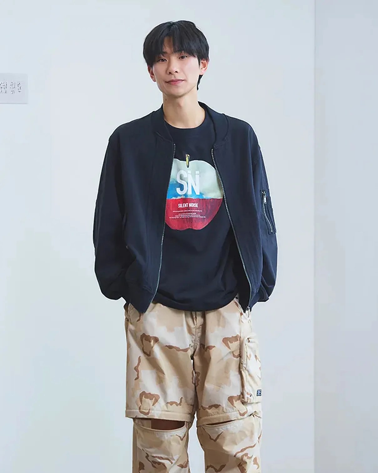 a man in a bomber jacket and camo pants
