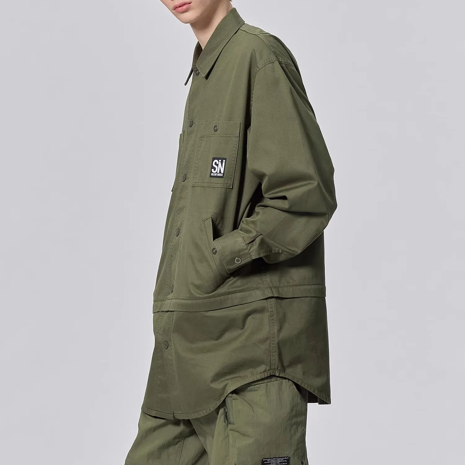 a man in a long green over shirt