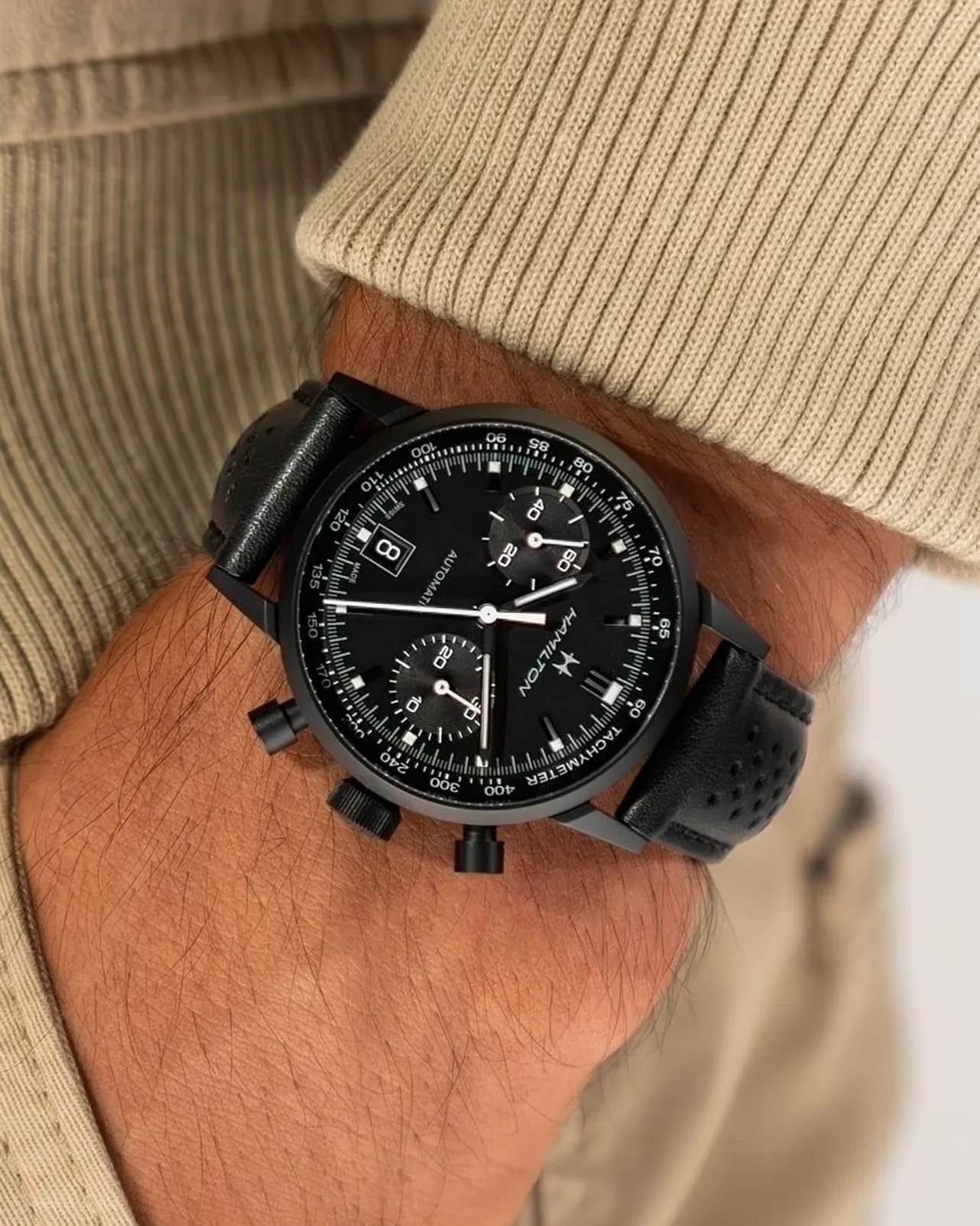 a black chronograph watch on a man's wrist