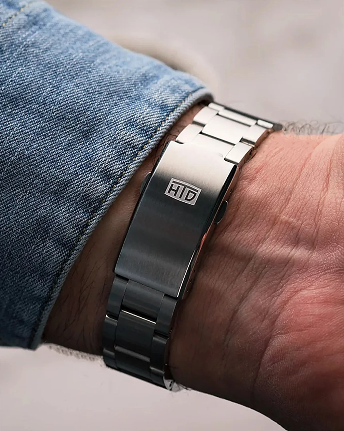 the clasp of a steel watch bracelet on a man's wrist