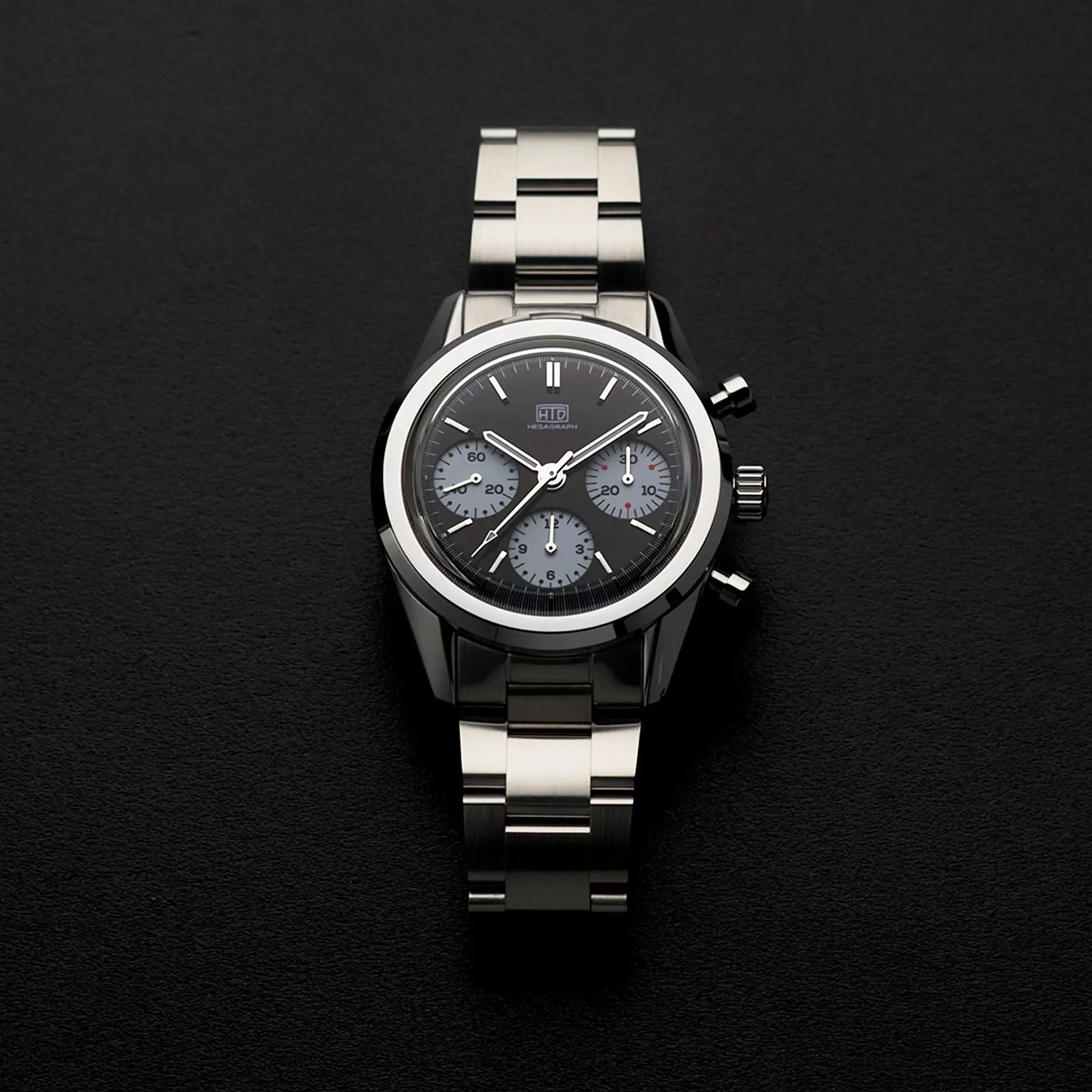 a steel chronograph watch on black bakground
