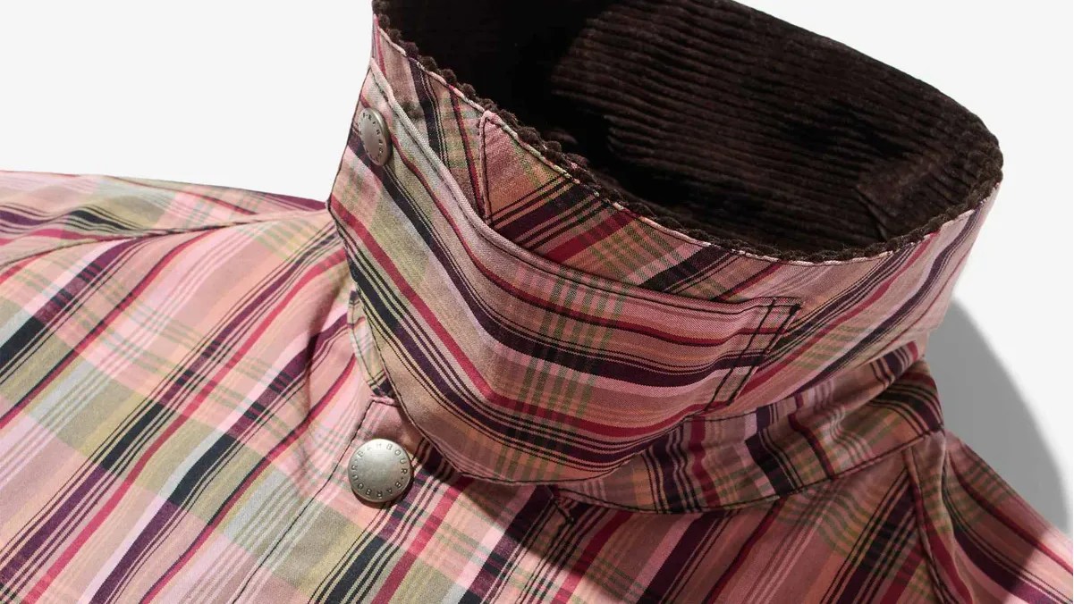 the propped-up corduroy collar of a pink plaid Barbour jacket