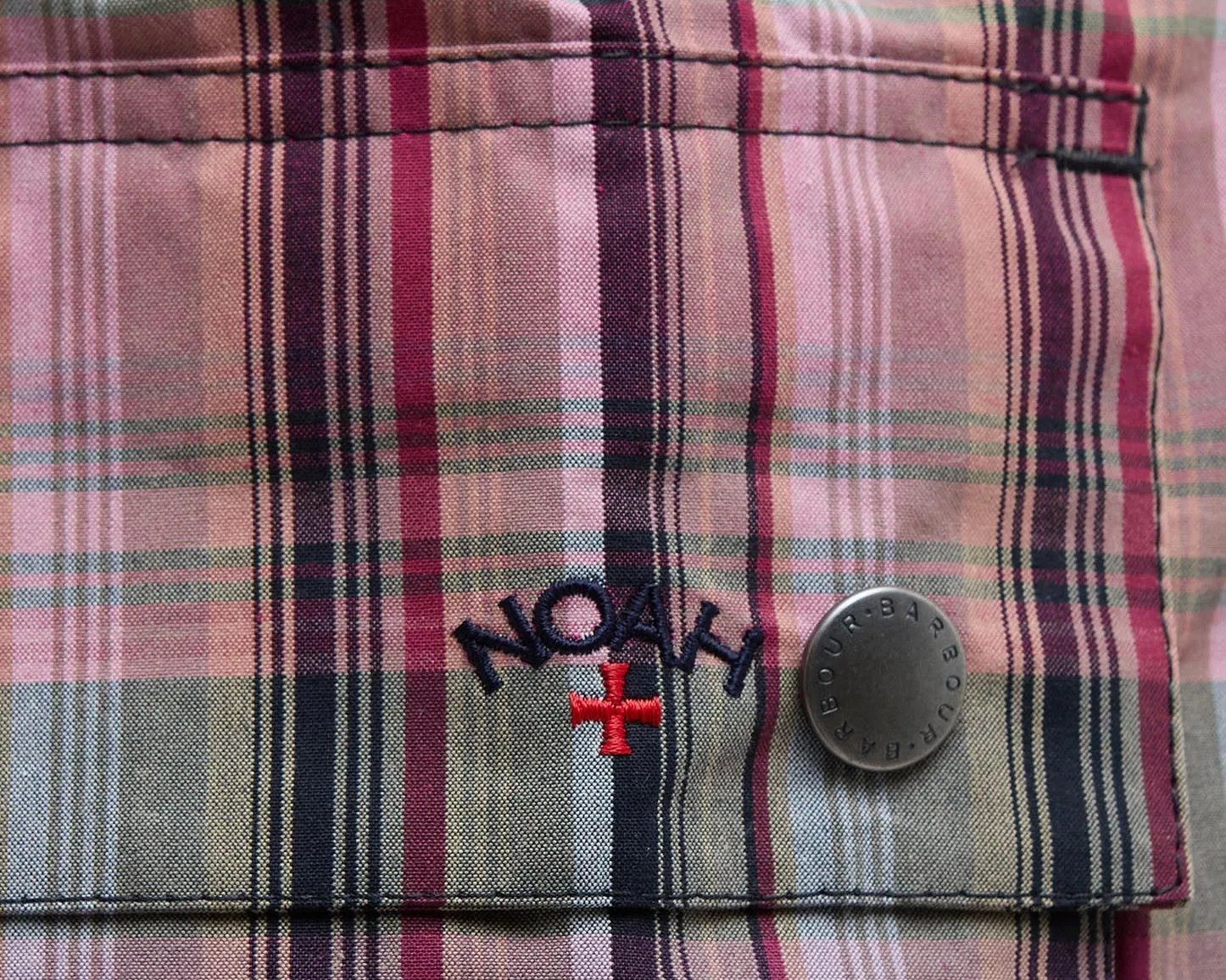 the Noah logo stitched onto the pocket of a plaid barbour jacket