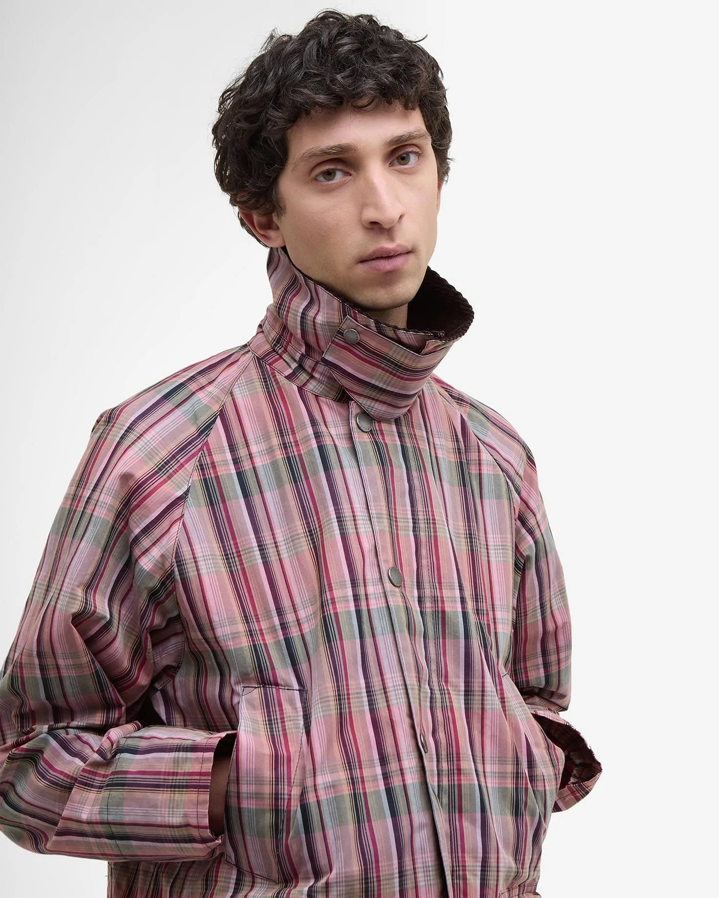a man in a pink plaid jacket with the collar up
