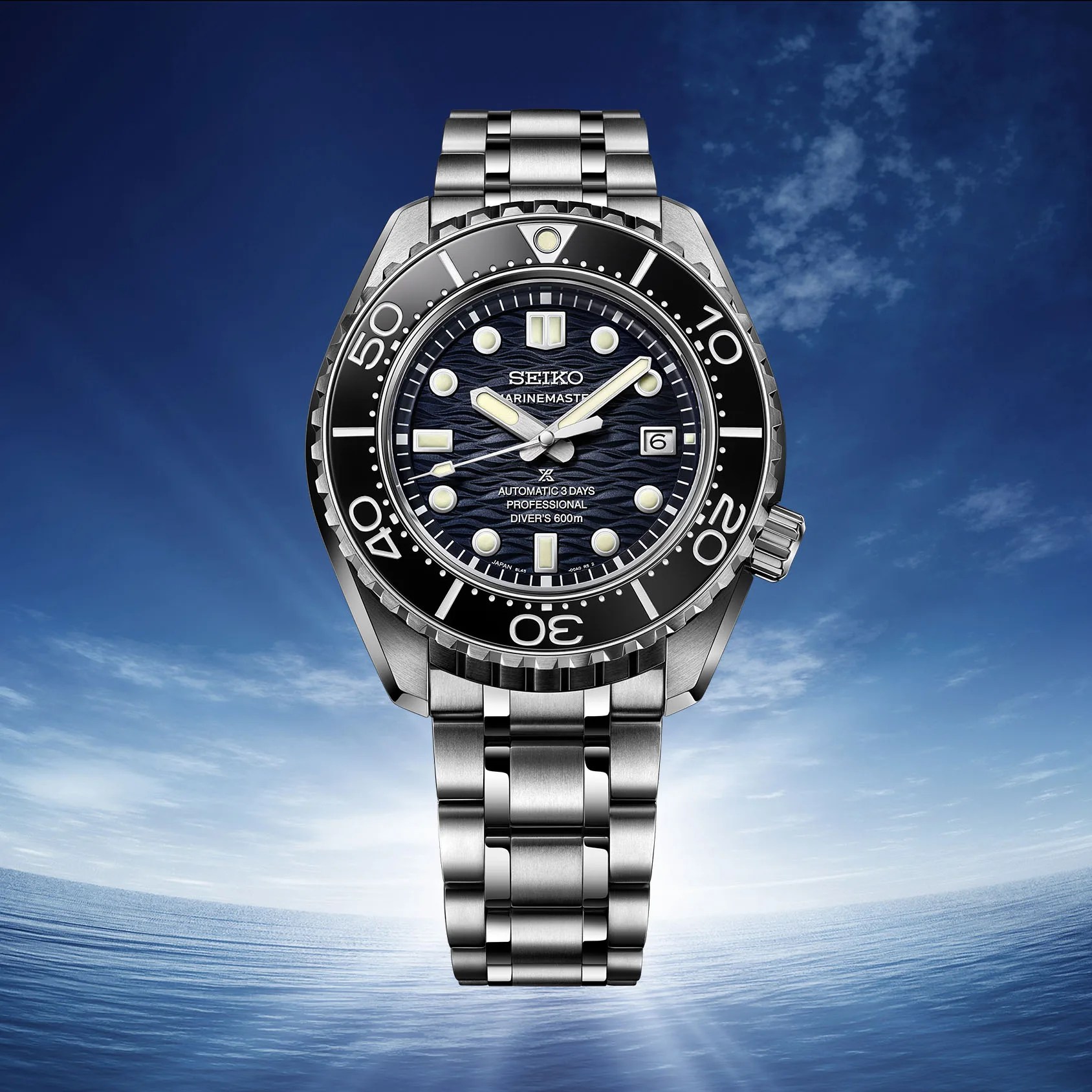 a Seiko Marinemaster dive watch with a blue sky and ocean background