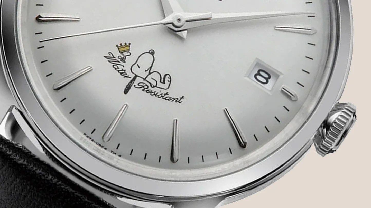 a white watch dial with Snoopy and Woodstock on it