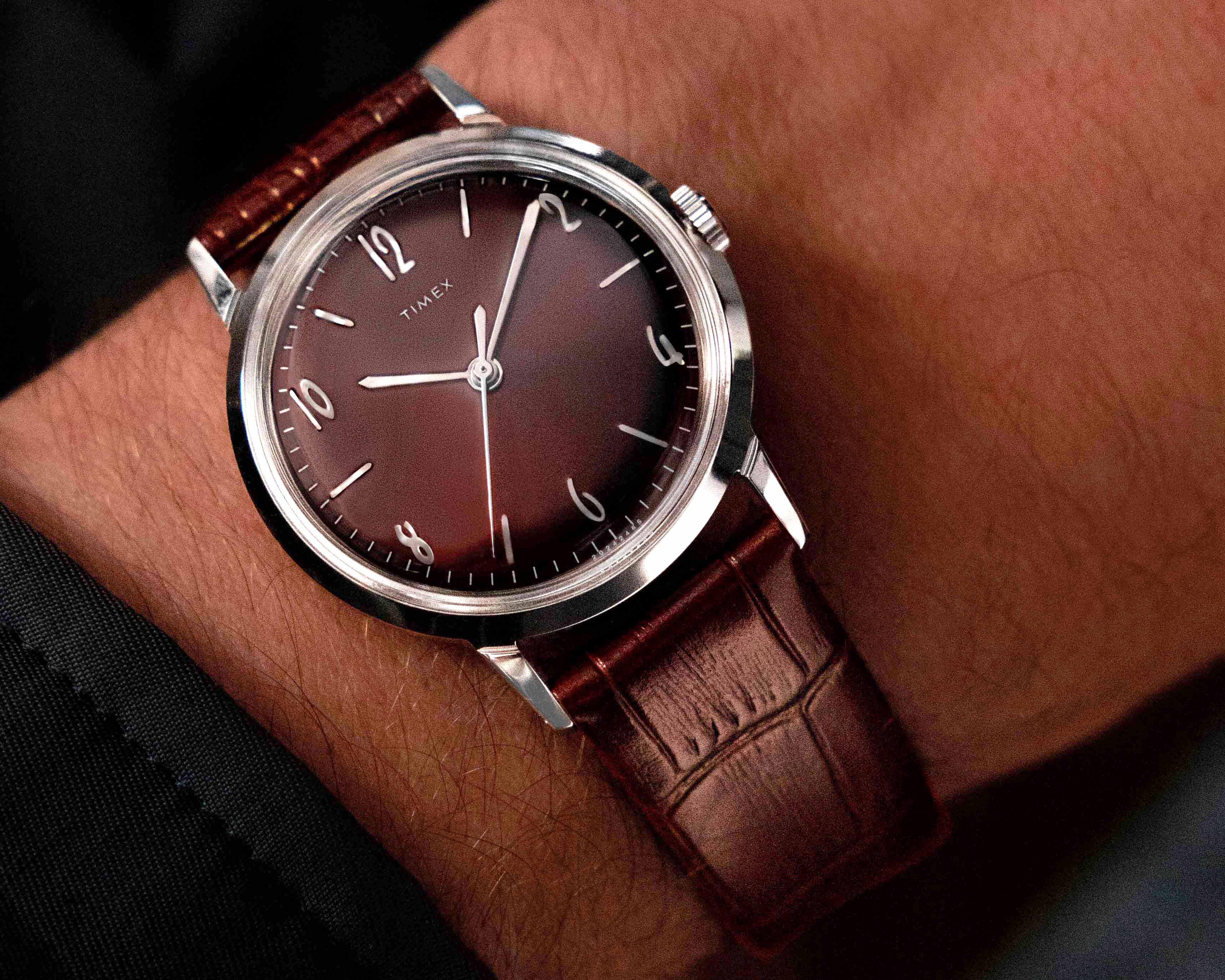 a burgundy dial dress watch on a man's wrist