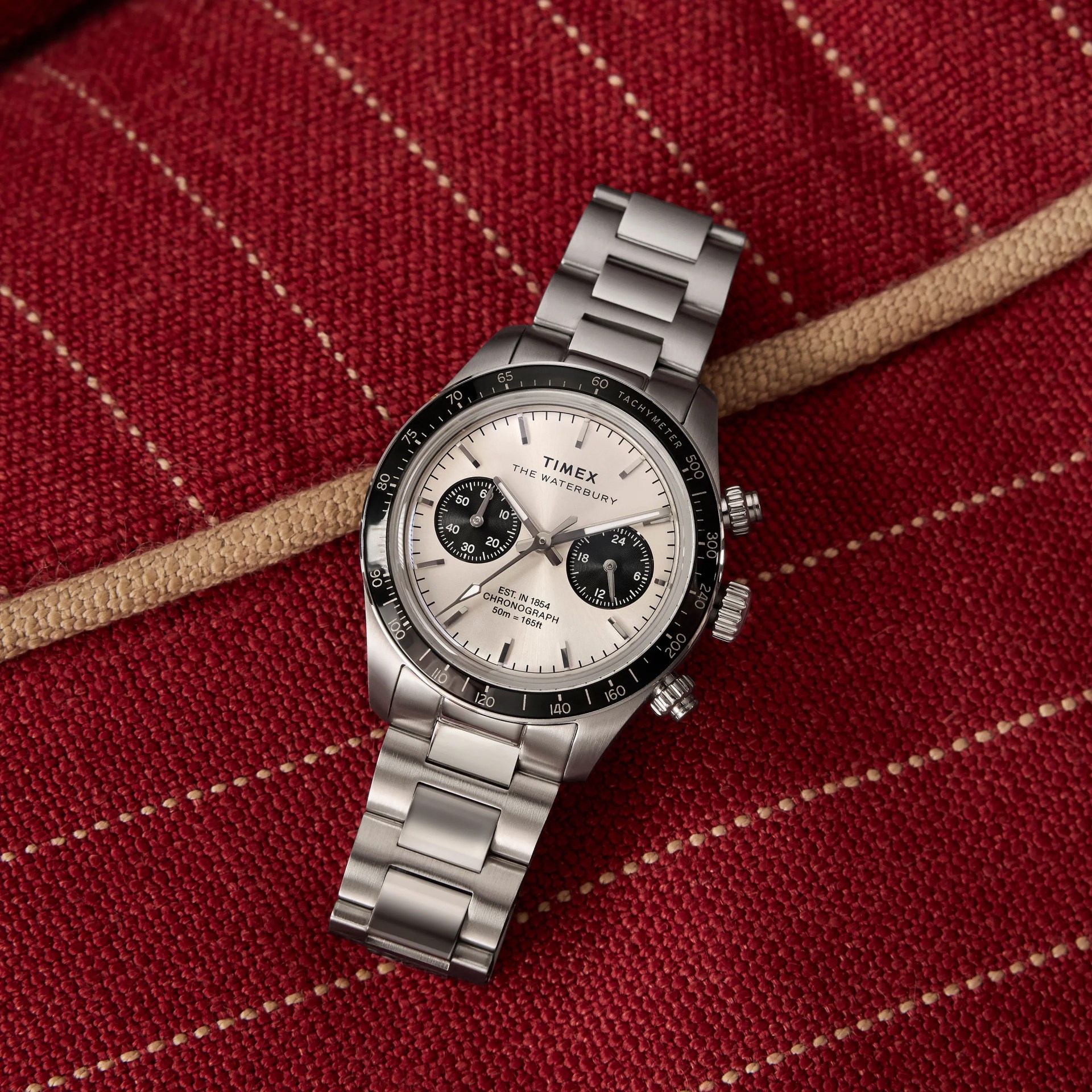 a Timex chronograph watch laying on a red couch