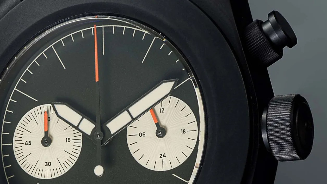 the black case and olive green dial of a Unimatic chronograph watch by Todd Snyder