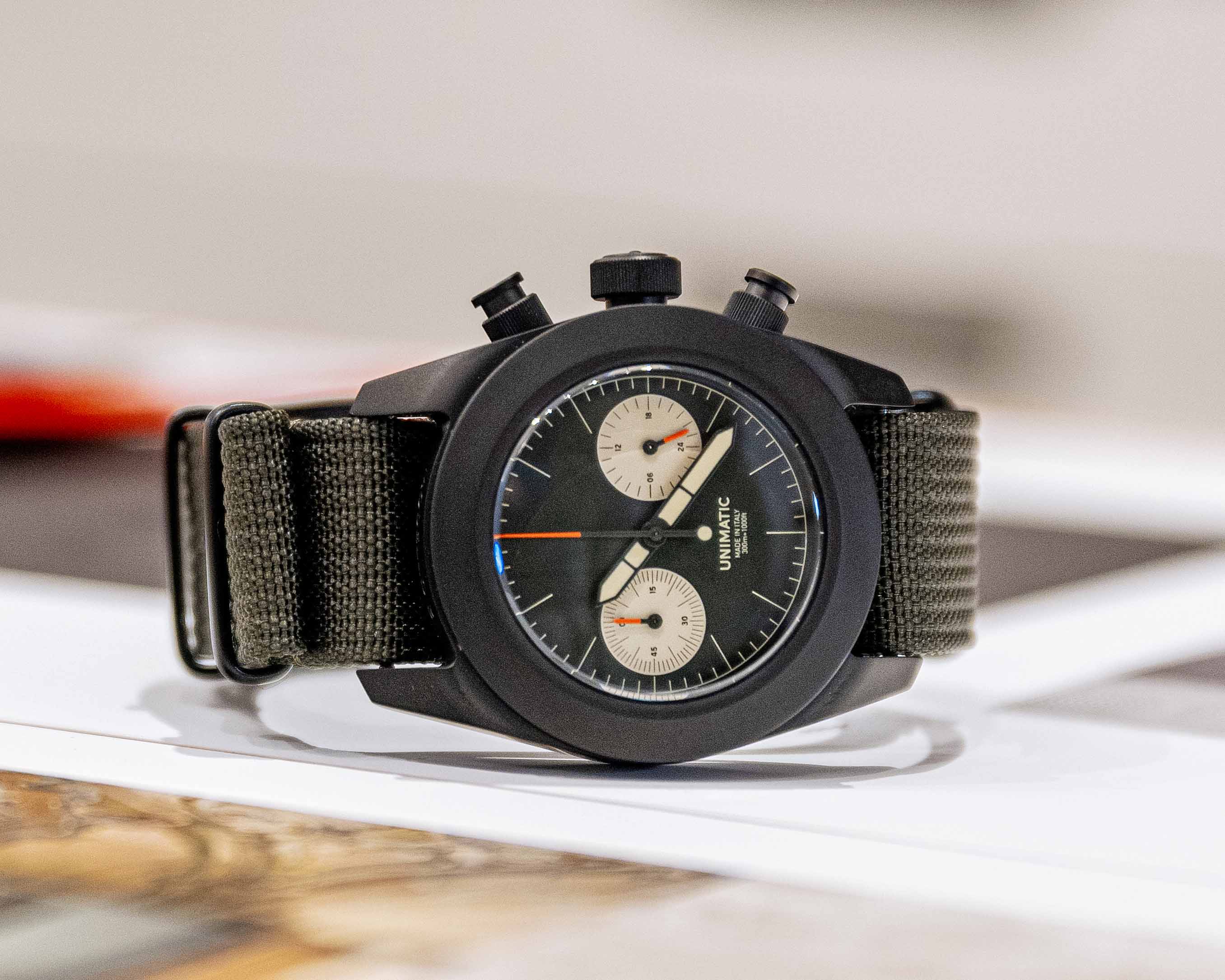 a black chronograph watch sitting on a deask