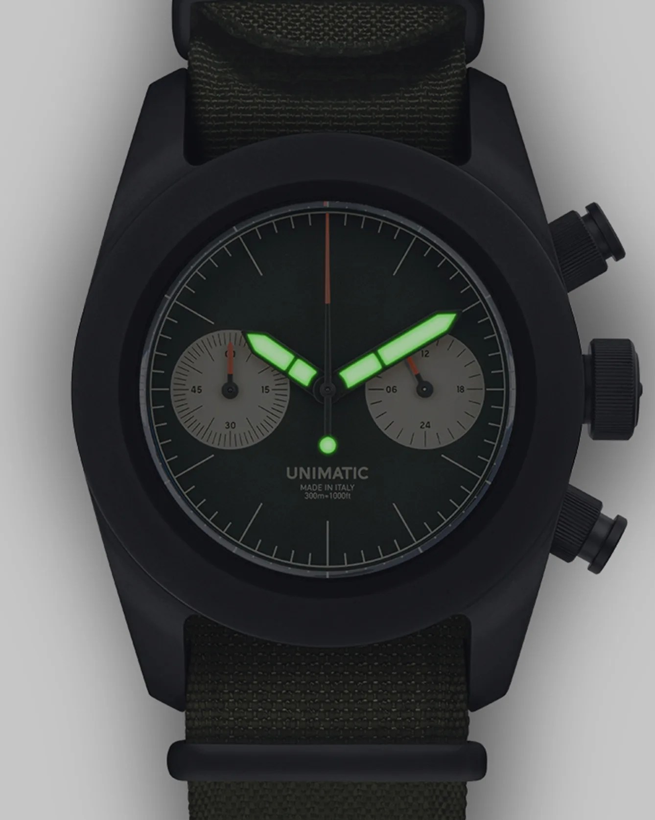 a black chronograph watch with lume hands glowing