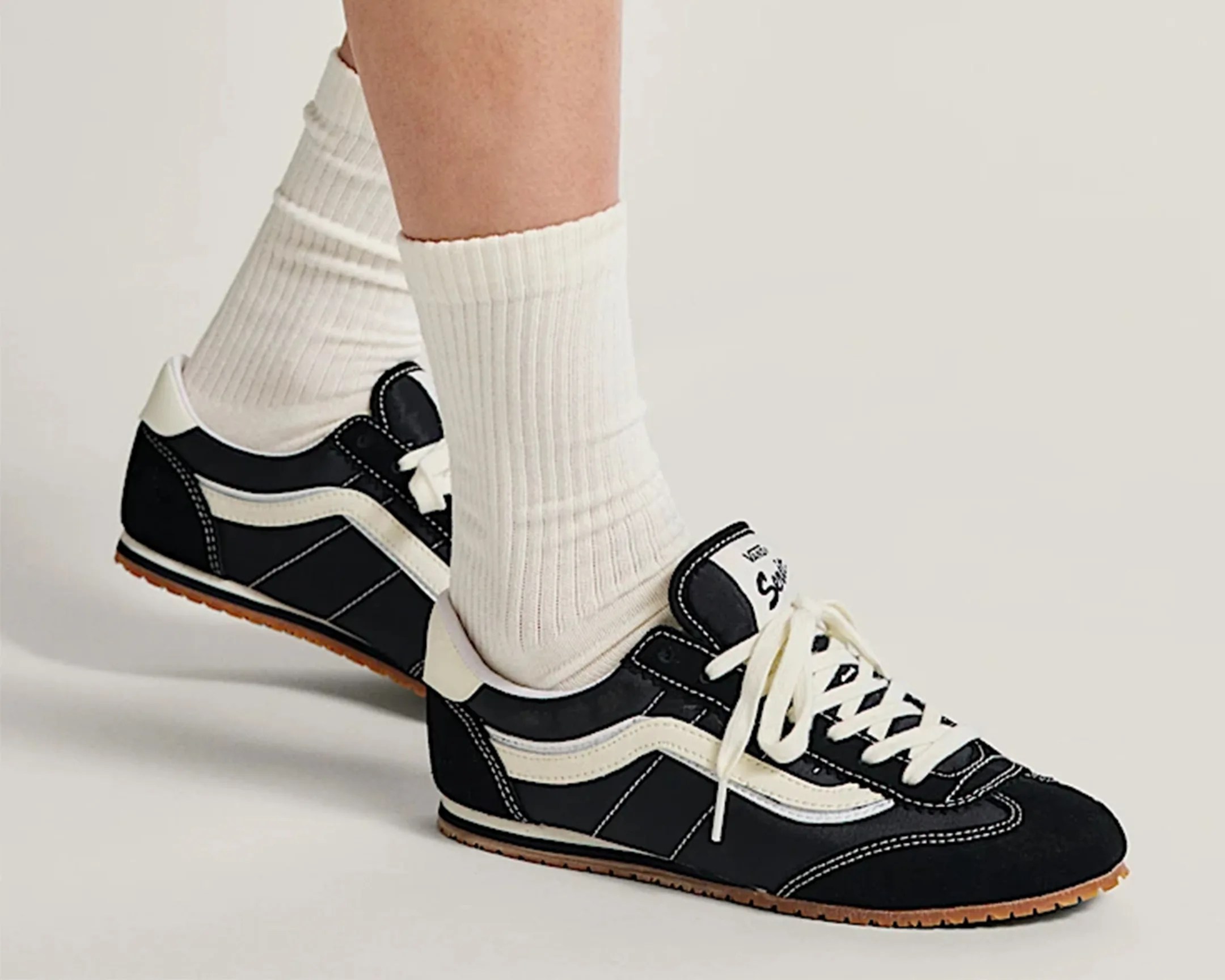 a man wearing a pair of black Vans sneakers