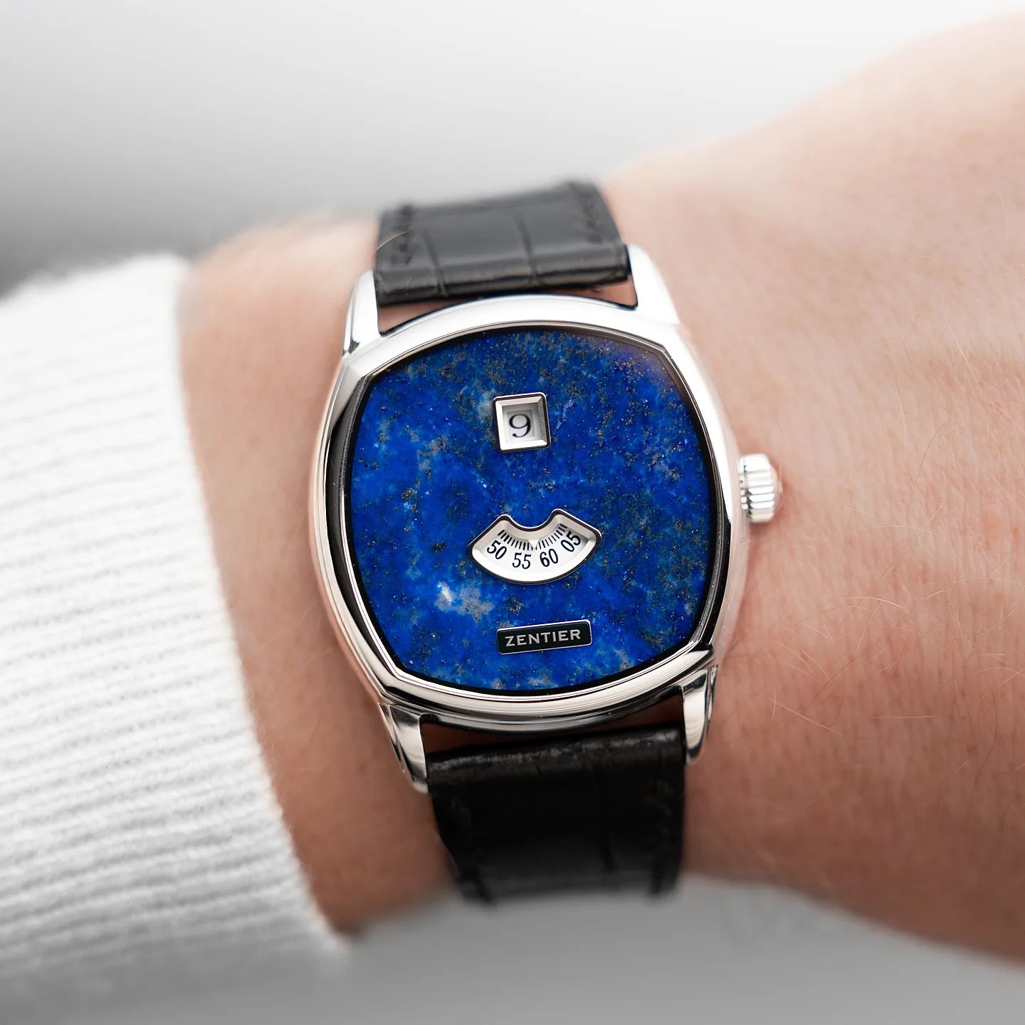 a blue stone dial dress watch on a man's wrist