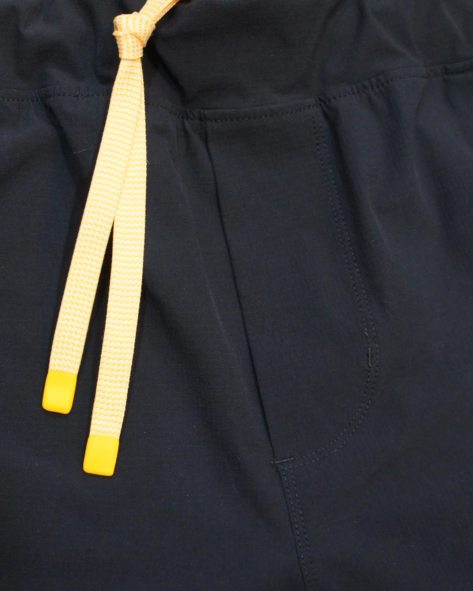 the yellow drawstring on a pair of black running shorts