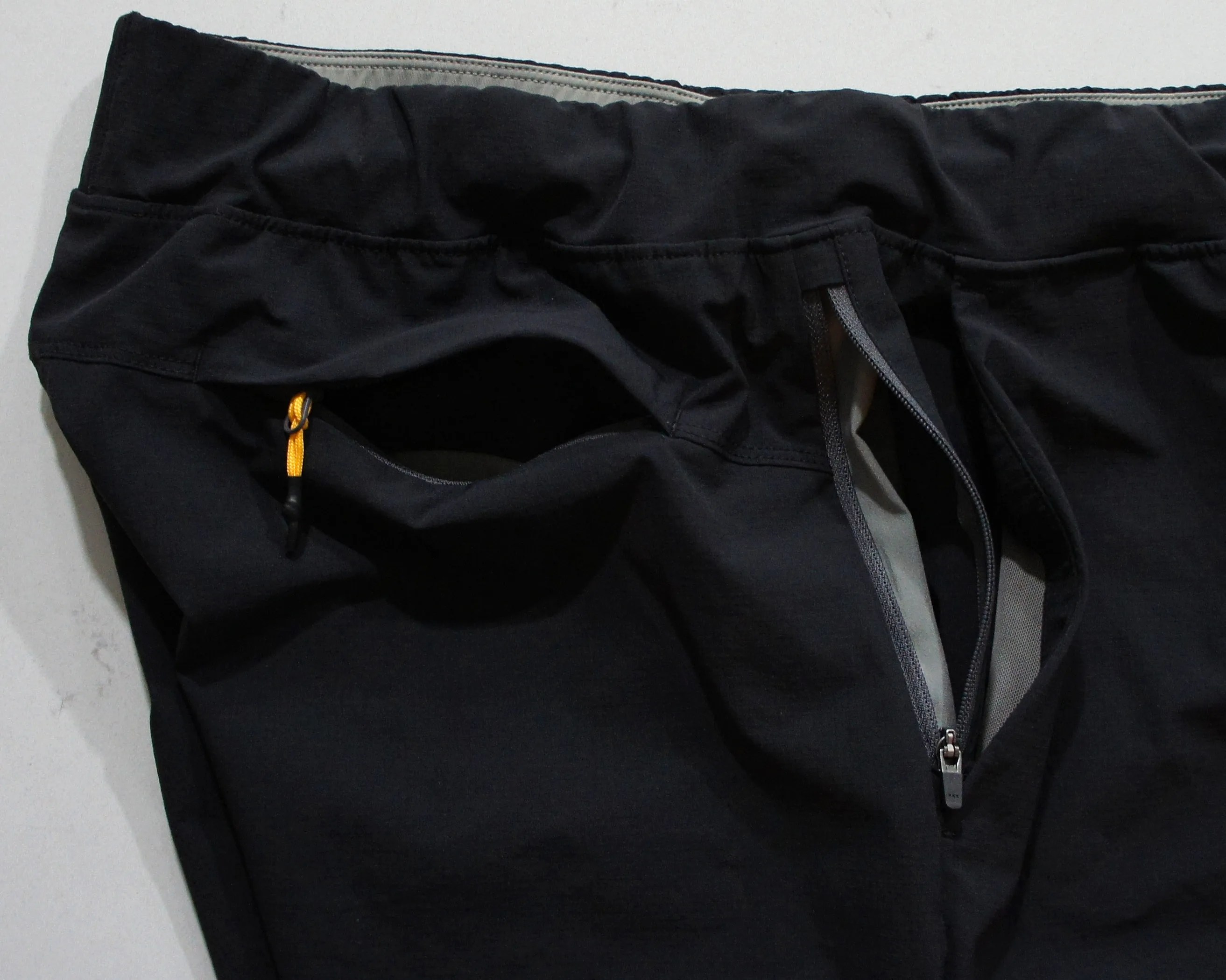 the open pockets of black running shorts