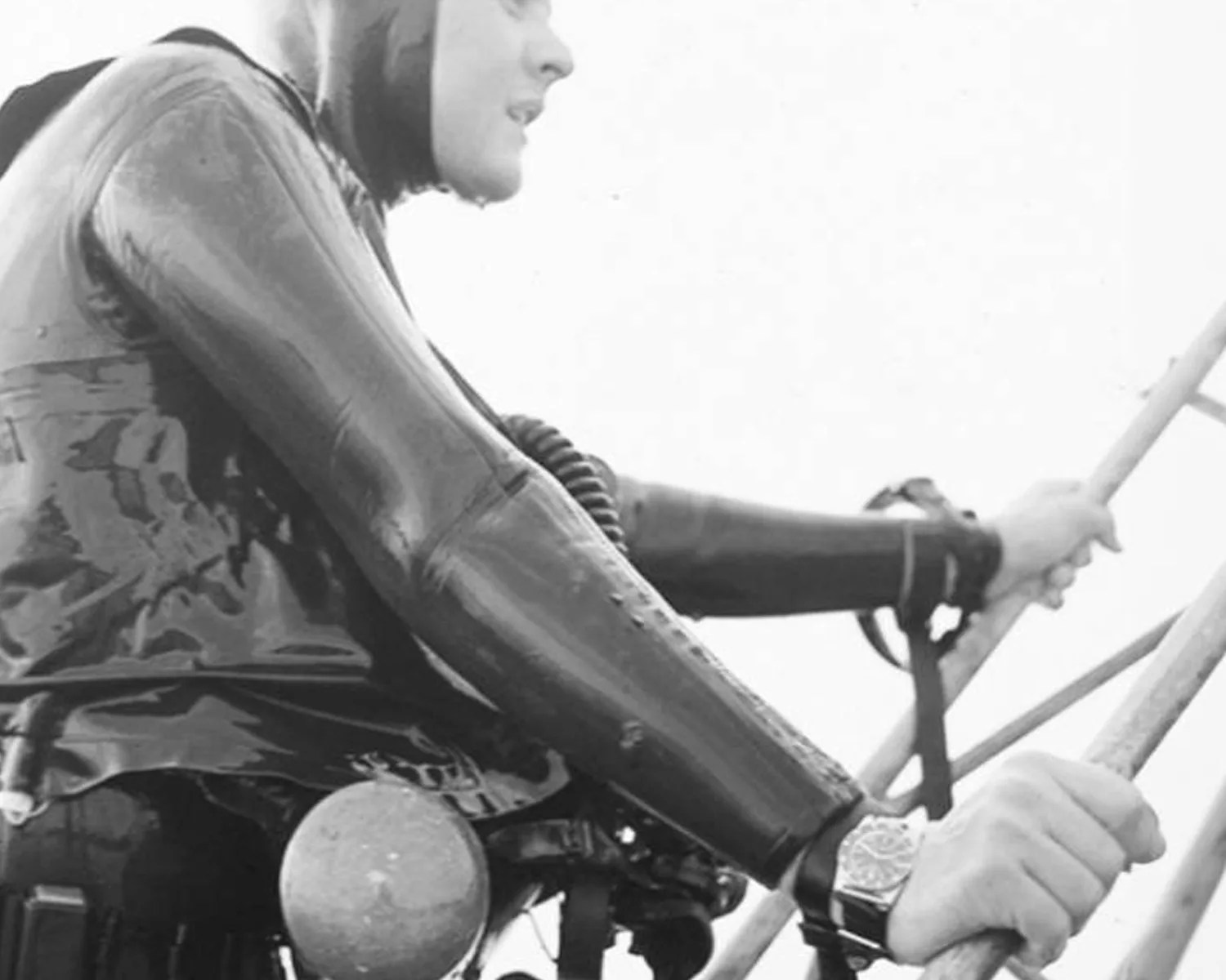 a man in a wet suit and SCUBA gear wearing a dive watch
