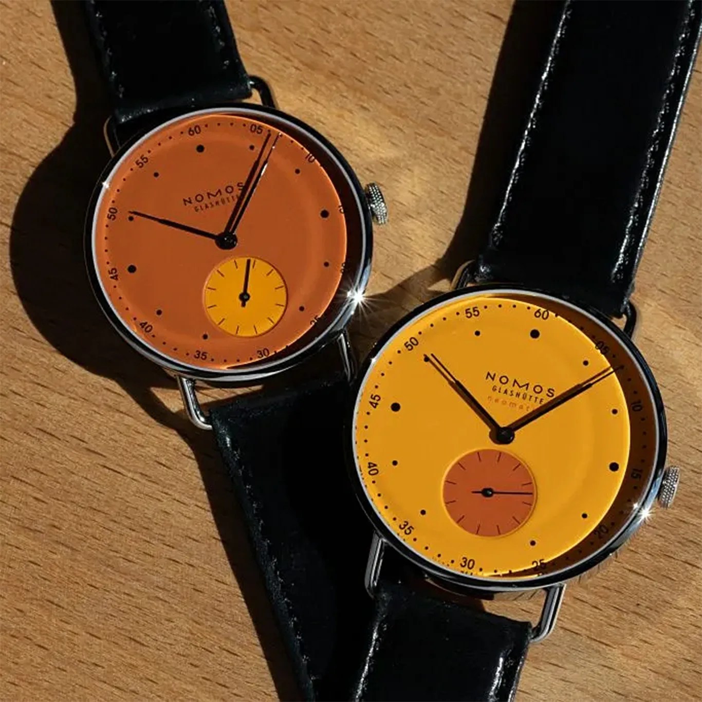 a pair of orange dial watches