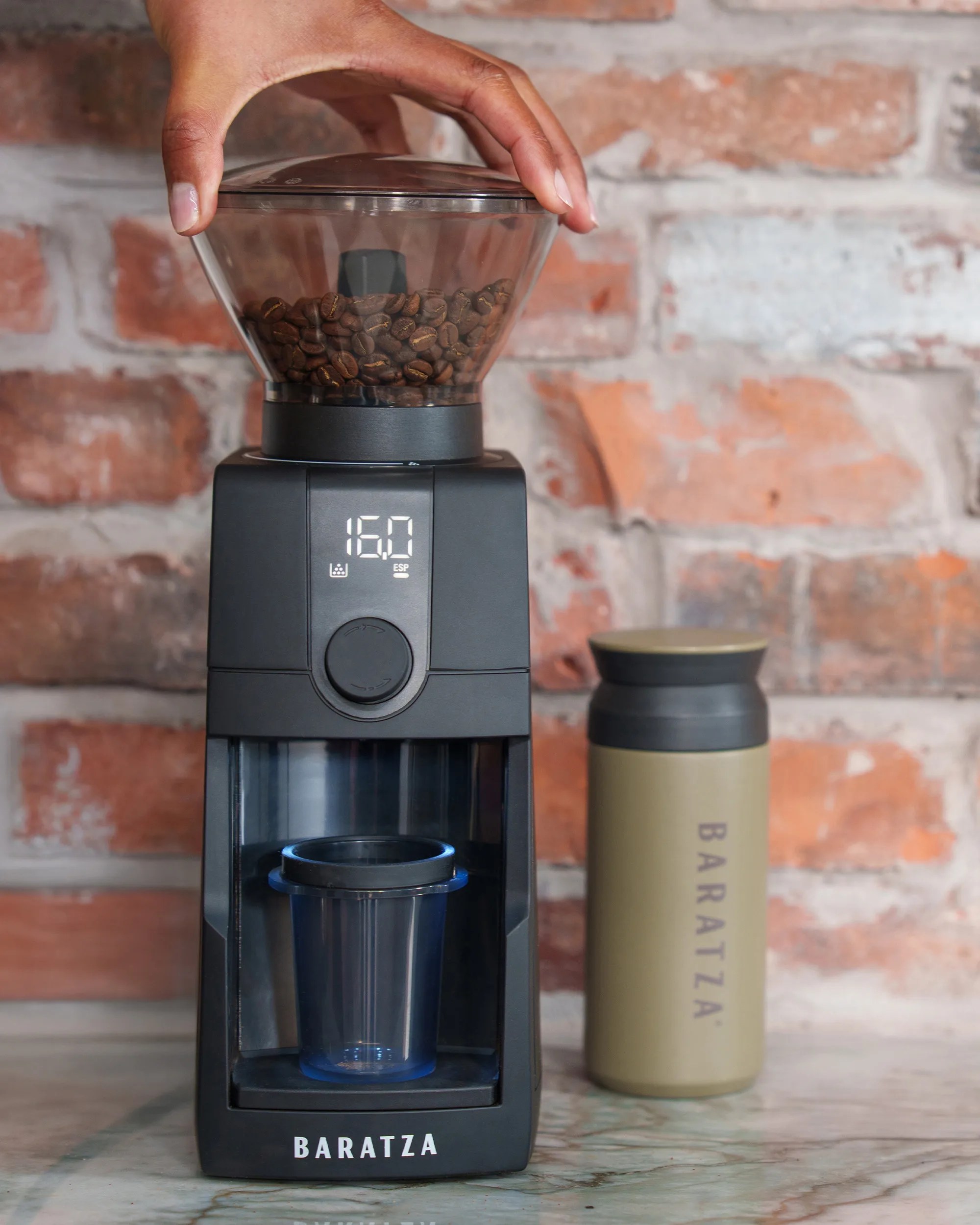 Baratza Encore ESP Pro Coffee Grinder with hopper and container in front of brick