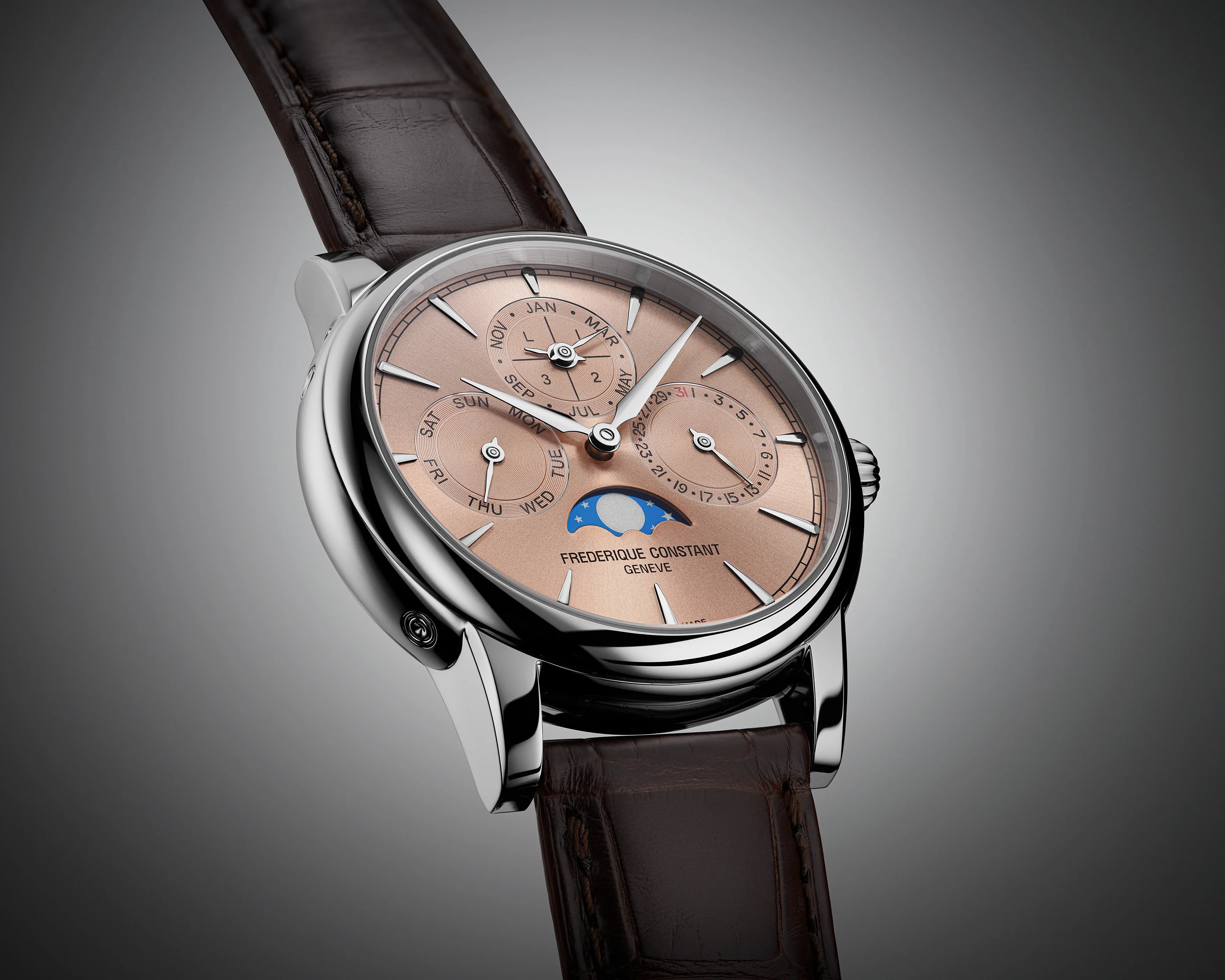 a steel perpetual calendar watch with a gold dial and brown leather strap