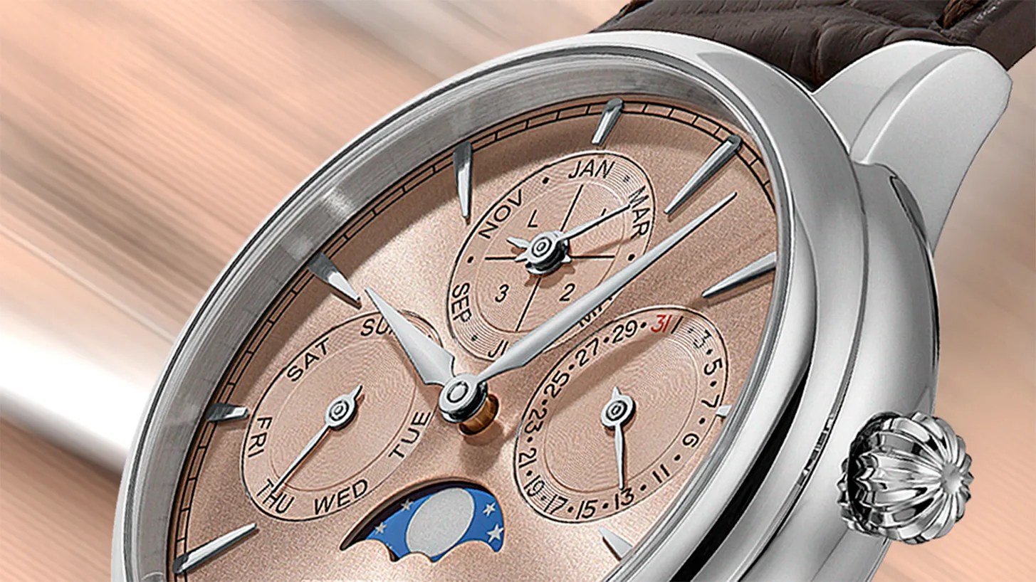 a salmon-colored perpetual calendar watch dial with a silver case