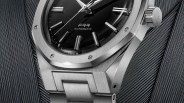 The bottom portion of the The Nivada Grenchen F77 Mark II in stainless steel shown against a metallic background image