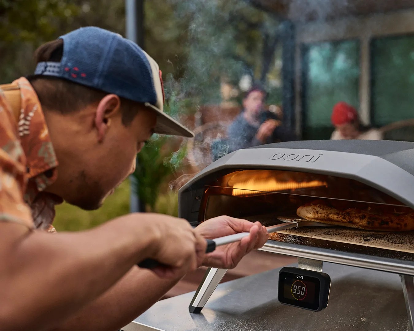 man getting pizza out of ooni Koda 2 oven