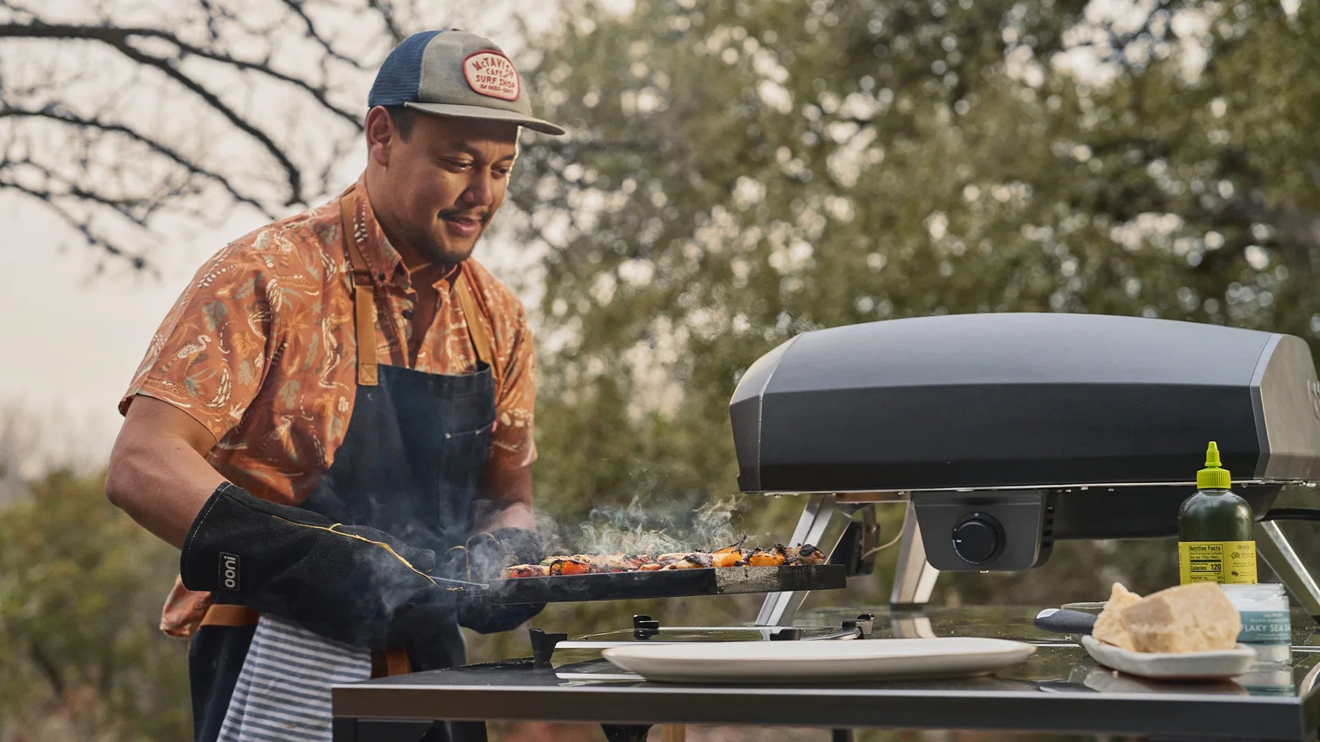 man taking pizza out of Ooni oven
