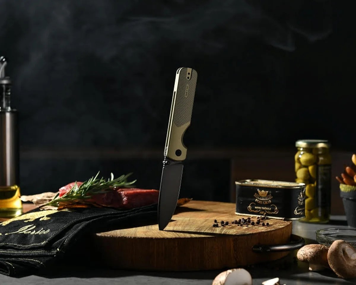 Oknife Duron Folding Knife stuck in cutting board with charcuterie ingredients