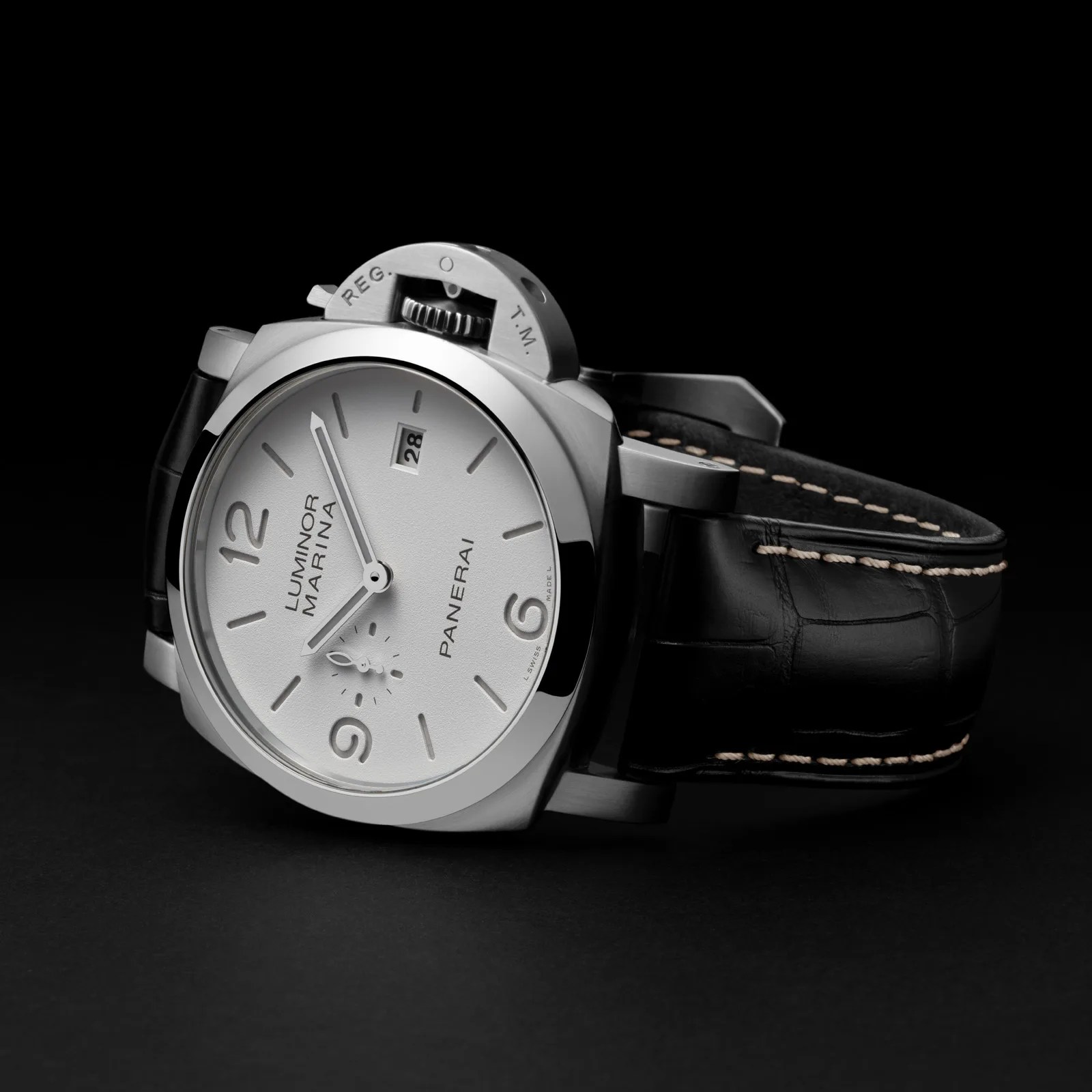 A 2025 Panerai Luminor Marina watch with a white face shown laying on its side against a dark grey background. 